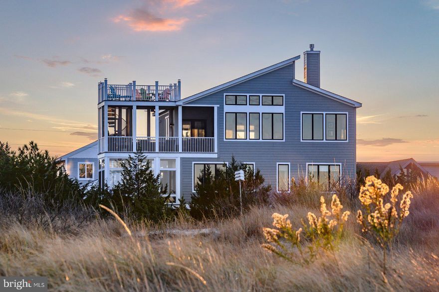 A Bayfront Sanctuary Where Every Sunrise and Sunset Steals the Show

Welcome to your private coastal retreat—where modern luxury meets timeless tranquility. Perfectly positioned on the serene shores of Broadkill Beach, this 2017 custom-built bayfront residence captures the essence of waterfront living with sweeping 360° views, seamless indoor-outdoor design, and elegant, sun-filled interiors.

Wake up to the sound of gentle waves and golden light reflecting off the Delaware Bay. Step onto one of your many balconies with coffee in hand as dolphins glide by in the distance, or gather with friends on the roof top deck and beach, as the evening sky transforms into shades of coral and violet over the refuge. Every level of this home is thoughtfully designed to frame the beauty of the bay—offering sunrise and sunset views that change with each season, yet always inspire awe.

Inside, over 3,000 square feet of refined coastal architecture await. With 5 spacious bedrooms and 3.5 bathrooms, this residence offers both intimate family comfort and open spaces ideal for entertaining. The inviting great room centers around a spectacular stone fireplace and flows effortlessly to multiple decks—perfect for savoring the views and sea breeze.

The chef’s kitchen is a coastal showpiece, featuring high-end finishes, custom cabinetry, and an expansive island—ideal for hosting brunches or sunset dinner parties. Every detail, from designer lighting to thoughtfully curated flooring, reflects a commitment to quality, sophistication, and effortless seaside living.

Outside, the 75X100 landscaped lot has been artfully designed for both beauty and function, with premium side yards, secure storage, an outdoor shower, and extensive hardscaping that complements the home’s natural surroundings. A concrete driveway with space for six vehicles ensures ample room for guests eager to share in your waterfront lifestyle.

Just steps away, the sandy beach invites morning walks, paddleboarding, or kayaking across the calm bay waters. As night falls, ascend to your private rooftop deck to stargaze beneath an endless coastal sky—a signature Broadkill Beach experience found only in homes of this caliber.

Whether as a primary residence or a luxury coastal escape, this rare offering promises more than a home—it delivers a lifestyle defined by peace, beauty, and connection to the water.

Sellers are open to negotiating the purchase of the brand-new Kawasaki Beach Buggy, paddleboards, kayaks, and Sunfish on a separate bill of sale making for instant beach enjoyment and fun memories in the sun.