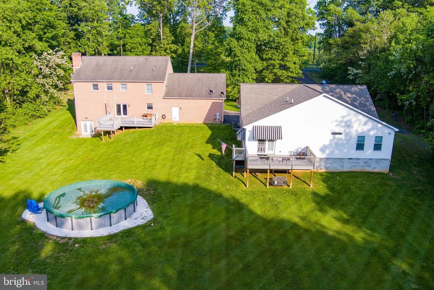 Gorgeous Huge Colonial. Renovated in 2018.  This house is waiting for a family with separate living needs to move in.   Main House has 4 bedrooms, 3 full baths, 2 half baths, kitchen, dining room, den, living  room, recreation room, 2nd kitchen downstairs. Enjoy nature from the huge front porch or the rear deck.  Decked out with hardwood, fireplaces , half bath of the kitchen, half bath in the oversized garage, Cabinets in the laundry rooms with drop sinks, utility room, potential wine cellar in the basement, barn doors and recessed lighting, quartz counter tops, plenty of storage in the pantry, potential 5th bedroom in the basement (no egress). Beautiful kitchen opens to a huge dining room with a fireplace make this a great country atmosphere.   A detached in-law suite was built in 2018 that consist of a huge 15x15 primary bedroom with ceiling fan, 12x10 primary bath with handicap shower and tub, 2 sinks , another 8x9 full bath, huge 20x18  kitchen with stainless steel appliances refrigerator, stove, microwave, dishwasher, island, 12x12 breakfast area, 14x21 living room and 7x13 laundry room with washer, dryer and built in cabinets.  This separate living facility has an attached garage, huge rear composite deck  and could be used as a separate rental or Air B&B. Above ground pool is another plus.   All this on a 2 very secluded lots just minutes from I81, shopping and  restaurants in South Berkeley.  20 minutes to Historic Martinsburg and Winchester VA.