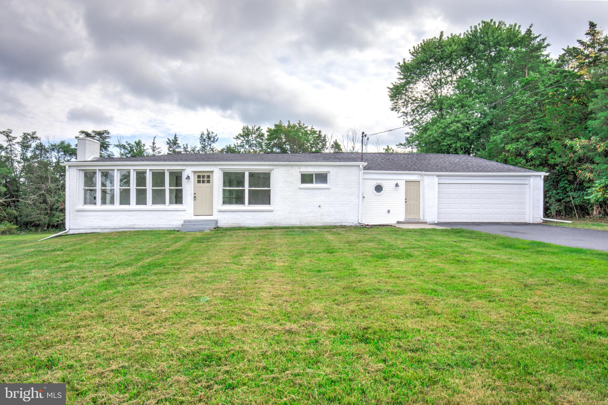 Welcome to this beautifully renovated ranch-style home, where modern upgrades meet timeless charm! Situated on nearly an acre of flat, usable land, this 3-bedroom, 2-bathroom home with attached two-car garage is designed with both style and function in mind. Step inside to an open-concept main living area that radiates character, featuring large windows that flood the space with natural light and a stunning brick fireplace that adds warmth and charm. The refinished hardwood floors throughout the home provide a cohesive and elegant feel. The living space seamlessly flows into a brand new, front-facing kitchen that is sure to impress. With sleek stainless steel appliances, a stylish tile backsplash, quartz countertops, and a spacious center island, this kitchen is perfect for both everyday cooking and entertaining. The three bright and airy bedrooms boast vaulted ceilings, creating an open and inviting atmosphere. The main bathroom is a true standout, featuring a double vanity and a tiled tub/shower combination for added convenience. The primary suite offers a peaceful retreat, complete with a private bath that includes a beautifully tiled walk-in shower for a spa-like experience. You'll love the large breezeway/mudroom area that leads to the attached two-car garage. The thoughtfully relocated main-floor laundry adds extra convenience to your daily routine. Additional upgrades include a new architectural shingle roof, an energy-efficient heat pump, newly sealed driveway and a brand-new septic system, ensuring peace of mind for years to come. This home is truly one-of-a-kind, offering a perfect blend of modern amenities, timeless character, and plenty of space for outdoor enjoyment. Don’t miss out—schedule a showing today!