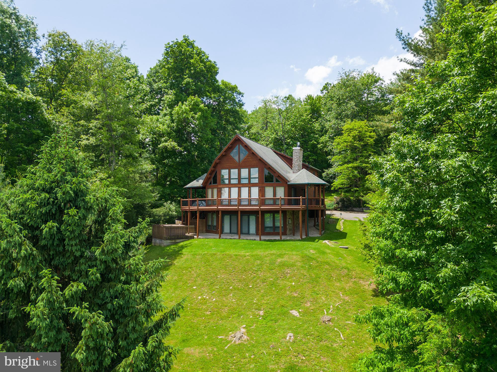 The only word that comes to mind upon entering this gorgeous log home is "wow". The abundance of windows allows you magnificent views of Deep Creek Lake from almost every room. The open floor plan offers the ideal space to entertain family and friends. Boasting two propane stone fireplaces, hardwood flooring, five bedrooms, three and a half baths and three levels of living space, this home would be an ideal permanent or vacation home. The outdoor space is just as inviting with a hot tub pad, large deck (part of which is covered), private drive and an additional 1.18-acre lot to the rear providing ample space for a garage or pool to be added in the future. The dock slip is close by and gives you lake access for your enjoyment. Call today to preview!