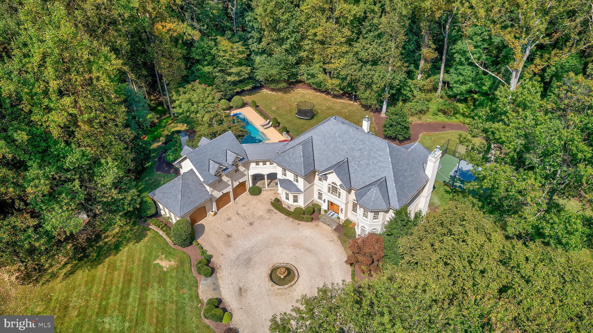 Elegant French Country Estate on 5 Acres
Nestled down a private country lane, this exquisite French country estate offers unparalleled elegance and tranquility on 5 sprawling acres. As you approach, you’re greeted by a grand circular driveway adorned with a stunning fountain, setting the tone for the luxury that awaits.
Step inside the 2-story grand foyer, where a magnificent chandelier illuminates the hardwood floors and a grand staircase that exudes sophistication. The formal dining room is a showstopper with its soaring 2-story ceiling, large Palladian window, and an elegant chandelier that adds a touch of timeless charm.
The formal living room, complete with a cozy fireplace, provides a perfect space for intimate gatherings, while the expansive family room offers a second staircase, hardwood floors, a fireplace, and direct access to the deck—ideal for both relaxing and entertaining.
The recently renovated kitchen is a chef's dream, featuring antique marble floors, Carrera marble countertops, and top-of-the-line appliances, including a Sub-Zero refrigerator and a 48" Wolf range. The large island, with seating for three, overlooks a charming casual dining area, perfect for morning coffee or intimate family meals.
The mudroom, conveniently located off the kitchen, showcases slate floors, custom cabinetry, a built-in bench, and cubbies—ideal for keeping everything in its place. A powder room is thoughtfully placed nearby. The mudroom also provides direct access to a covered portico, seamlessly connecting the garage, front driveway, and pool area, making it as functional as it is beautiful.
For those who appreciate a quiet retreat, the library offers built-in bookcases, a window seat, and plantation shutters, creating a serene space for reading or working from home.
The upper level is home to a spacious and elegant owner's suite, featuring a cozy fireplace and a private Juliet balcony. The suite includes a custom dressing room with California Closet cabinetry, leading to a luxurious owner's bath that rivals a country inn, complete with an oversized frameless glass shower, dual vanities, and a large soaking tub. Bedroom 2 offers a newly renovated ensuite bathroom with plush carpet, while Bedrooms 3 and 4 share a newly renovated buddy bathroom, with each room boasting walk-in closets. A loft sitting area at the top of the second staircase leads to Bedroom 5, which features cathedral ceilings and another newly renovated bathroom.
The lower level of this home continues to impress with a full bath featuring a large shower and single vanity, a newly added laundry room with custom cabinetry, a sink, and a tile floor. The lower level also includes an exercise room, a game room with French doors leading to the exterior, and a large recreation room perfect for hosting movie nights or gathering with friends to watch the big game.
Enjoy resort style living in your own backyard, boasting a beautiful sparkling pool with an adjacent patio perfect for dining, and a pergola with a large, stacked stone wood-burning fireplace set in a peaceful setting. The property also features a sport court, providing endless opportunities for outdoor fun.
This property offers a perfect blend of elegance, comfort, and practicality, making it a truly remarkable place to call home.