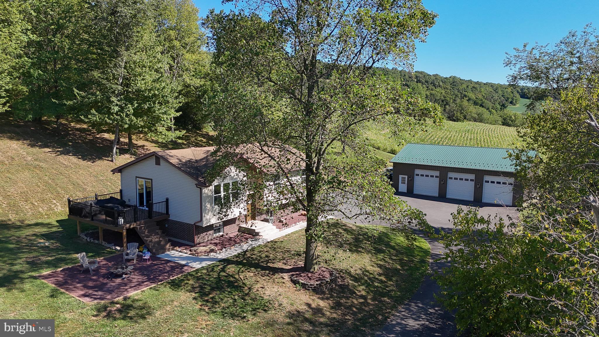 SELLER HAS ACCEPTED OFFER! Surrounded by rolling wooded hills and farmland, its newly paved driveway stretches through a bank of mature trees, a bend revealing the lovely home. While the setting is truly remarkable, the home itself has been thoughtfully and lovingly updated throughout while its detached garage is a marvel! The home is accessed via new concrete walkways leading to the front door and into a foyer area, sweeping up into an open concept gathering space with living room, dining area and kitchen. Wood accents in custom railings, cabinets, and paneled ceiling offer a tremendous warmth to the heart of this home, while a bespoke alcove allows for a television’s discrete presence. The kitchen is a prime example of the home’s rustic aesthetic with ideally chosen backsplash and counters, offering thoughtful style to a truly functional space, a large peninsula doubling as worktop and dining counter! Sliding doors offer deck access for easy indoor-outdoor entertaining. The updated full bath maintains the warm aesthetic and features a beautiful tile surround with built in accent shelf in the shower. The three bedrooms are well sized with ample closets, the primary featuring a double. You will find new flooring throughout the main level. Downstairs, a second updated full bath offers a large stall shower, while the spacious family room hides a convenient laundry facility within! The finished spaces pair with a two-car built-in garage. Outside, just below the 15x12 composite deck is a 17x16 gravel gathering space, ideal for a fire pit; these living spaces set capture the south facing views. On the home’s other side, an approximately 75x60 paved area for parking and vehicle storage; or with some elbow grease and creativity, room for a regulation basketball half-court or full regulation pickleball court! Beyond, a 1680sf garage boasts three 10x10 garage doors, concrete floors, a 16x6 loft storage area, and more! Clearance to beams, 11’9” with an 18’ roof peak allows for more storage in the rafters. While in a wonderful country setting, the home has easy access to Routes 309 and 443, making for short drives to the convenience of both Tamaqua and Lehighton. Bonus, Tamaqua School District graduates qualify for the two-year LCCC scholarship program! Style and substance, marvelous location, do not miss this tremendous property.