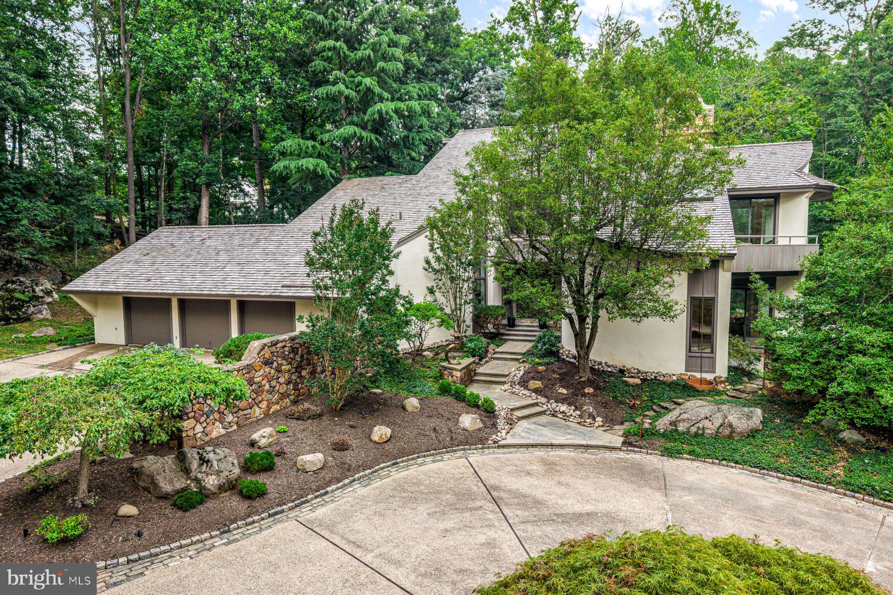 This stunning sun-filled contemporary home is nestled on a private 3.8 acre parcel at the end of a quiet cul-de-sac in picturesque Chester County, only minutes away from renowned schools, the Devon train station and heart of Wayne. Offering 6 bedrooms, 7 full and 1/2 baths, it was custom built with breathtaking Mark Stanish designs and superior Pohlig construction with luxurious amenities throughout, and includes a relaxing pool and spa with waterfall within its serene grounds. Light pours into every inch of this residence with extraordinarily oversized windows welcoming in not only the sunlight but also the incredible views of the surrounding grounds. Features include a soaring 3-story foyer with gleaming travertine marble flooring, an open piano area bathed in sunlight from a stately 3-story window, spacious living room with oak floors, gas fireplace with historic carved stone mantle surround and sliding doors leading to a slate terrace, cozy office/study with privacy pocket door, oak floors, circular accent wall, steps leading to the lower level wine cellar, and 3 window sliding door to slate terrace, spacious dining room with marble flooring, floor to ceiling mirrored wrap around wall and oversized sliding doors leading to a private deck, fabulous custom kitchen with plenty of countertop prep space, ample cabinetry storage, Gaggenau appliances including gas cooktops, grilling station, an induction cooktop with range hood, Bosch dishwasher, double oven, and Sub-Zero refrigerator/freezer and ice maker, breakfast room with windows on all walls and easy access to the slate terrace and outdoor grilling area, adjacent family room with soaring 18 foot vaulted ceiling and windows, built-in cabinetry, white stone wall with gas fireplace, and sliding door leading to deck. The dramatic main staircase leads up to the upper levels with the second floor presenting a glass bridge leading to a private and luxurious primary bedroom suite with circular window wall, outdoor deck, 14 foot heated cathedral ceiling, primary bath with two person Jacuzzi tub with Rojo Alicante marble tile surround, heated flooring, two person seated shower and two walk-in closets. Four additional bedrooms, one currently used as an office, can be found on the second level, each with ensuite bath, as well as an 8x10 foot fully paneled cedar closet with built-ins. The third level offers generous office space as well as a guest suite overlooking the foyer, with ensuite bath and private deck. The expansive lower level is perfect for everyday recreational activities and entertaining offering a media room with fireplace, mirrored exercise room with full bathroom, Art deco style kitchenette, custom crafted bar, classic brick wine cellar with custom oak 550 bottle storage, wine tasting room with wood burning fireplace and more. Move right into this one of a kind masterpiece!