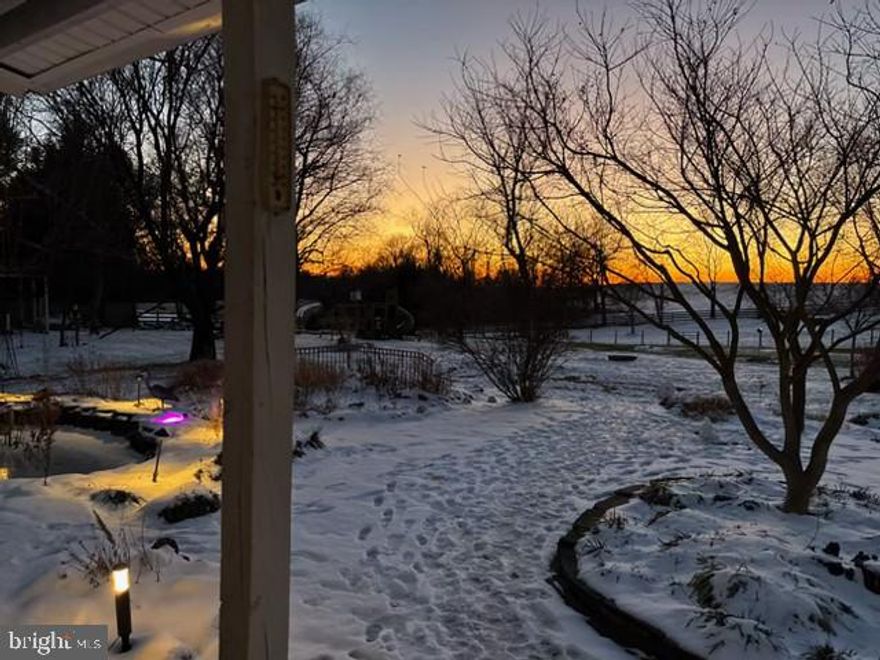 Step into timeless charm and rich history in this extraordinary Farmhouse–style home, originally built in the 1700s as a log cabin tavern. By 1850, it had become a dry goods store, and over the centuries it has been thoughtfully restored and updated while preserving its remarkable character.

From the moment you arrive, stunning molding, historic touches, and modern luxury plank floors flow throughout the main and upper levels. The inviting foyer features a Victorian-style woodstove and trim that sets the tone for the home’s historic appeal. Just off the entry, a large family room offers its own fireplace with crown and chair rail molding, while the expansive living room is perfect for both formal entertaining and everyday living. The flooring has been completely rebuilt to ensure structural integrity.

A separate formal dining room with elegant touches opens seamlessly into a breathtaking, light-filled sunroom with skylights and panoramic views of the surrounding homestead landscape. French doors lead to a covered rear porch with a ceiling fan, making it an ideal spot for outdoor dining, morning coffee, or evening gatherings. The bright kitchen features recessed lighting, a large farmhouse sink, stylish painted cabinetry, a new backsplash, a cozy breakfast nook, a garden box window, and both a pantry closet and walk-in pantry. A convenient half bath completes the main level.

Upstairs, the open and versatile landing area is perfect for a library or sitting area. The spacious primary suite offers a private full bath with a unique vaulted ceiling, a new double vanity, and updated LVT flooring. Three additional generously sized bedrooms complete the level, including one with its own fireplace, along with a full hall bath with a custom built-in vanity and a second-floor laundry room for everyday convenience.

The land is just as special as the home itself and feels like a private retreat. Custom patios create distinct spaces for entertaining, dining, and relaxing. Large koi ponds with a waterfall feature provide a peaceful focal point, while mature trees, lush gardens, and professional landscaping surround you in natural beauty. Raised garden beds for herbs and vegetables allow you to tend your gardens while enjoying sweeping views of the property. The fully fenced yard, newly fenced pastures, and a new horse run-in shed with water access provide an immediate home for precious, or future, animals.

The property features seven total structures: the main house, a cottage, charming potting shed, chicken coop, feed shed/rabbit shed, run-in horse shed, and a 350 SF equipment storage shed. 

The on-site cottage is separately metered with the power company and has water potential, offering excellent flexibility for a home business or guest space. The cottage also has a pigeon house built onto it which could be used for other animals. Behind the outbuildings, a mature orchard produces apples, nectarines, plums, peaches, pears, and cherries. 

Recent infrastructure upgrades include new well lines, a new 500-gallon poly tank, and a new hot water heater, adding peace of mind and modern reliability. With walls an impressive 16 inches thick, the home stays naturally cool in the summer and warm in the winter, a testament to its enduring craftsmanship.

This property comes with a second 0.67-acre parcel. This exceptional home offers space, history, character, and tranquility, perfect for those seeking classic farmhouse charm with incredible indoor and outdoor living.