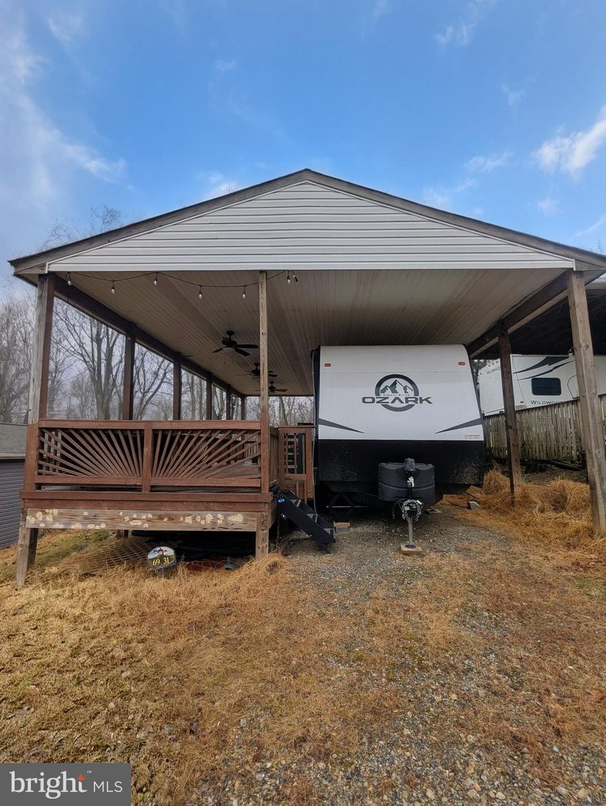Sewer Lot
This remarkable property includes a fully equipped 2024 Forest River Ozark 2670 RK Camper, perfect for outdoor enthusiasts. The spacious deck is designed for relaxation and entertainment, featuring installed electricity and fans to keep you cool during warm summer evenings. The private backyard is generously sized and seamlessly backs up to a serene wooded area, offering a peaceful retreat and a beautiful natural backdrop. 

This is a secured, gated community, and access begins at the guard shack. Make sure to bring your ID to the office or guard shack for your visitor pass. **THIS IS A SEASONAL CAMPGROUND, OPEN FROM APRIL 1 TO NOVEMBER 1.**

River Bend is a premier, privately owned 400-acre recreational vehicle camp resort designed for seasonal enjoyment. Nestled along the picturesque Upper Potomac River in West Virginia, River Bend stands out as one of the state's most sought-after family destinations, just a short drive from the bustling Washington and Baltimore metro areas. The park is fully operational with utilities from April 1 to November 1, and lot owners enjoy year-round access to their properties.

**Membership Benefits Include**:
- Breathtaking views and diverse wildlife
- Prime access to the Potomac River
- Scenic hiking trails
- Refreshing swimming pools
- Fun-filled mini-golf
- A vibrant youth center
- Well-maintained tennis and basketball courts
- Convenient laundry facilities
- A well-stocked convenience store, deli, and lounge
- Clean and modern bathhouses throughout the park
- A boat ramp for easy water access
- An inviting bar and grill
- A church right on the grounds

At River Bend, the fun never ends! Join in on various exciting activities, including Fourth of July fireworks, a lively carnival, bonfires, poker runs, horseshoe tournaments, car shows, Halloween trick-or-treating, and so much more!
