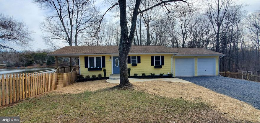 Amazing view of Hidden Lake from covered porch and picture window.  Corner lot with fenced area.  Beautiful lot has been cleared and ready for your Family to enjoy this water oriented home.  Completely renovated with wood flooring, granite counter tops,  NEW stainless steel appliances, NEW Washer and Dryer, NEW lighting fixtures and ceiling fans.  Kitchen includes NEW cooking island, NEW windows,  NEW carpeting, fresh paint, NEW hot water heater, oversized 2 car attached garage with attic storage.  Newer roof and central HVAC and water softener system.  Hook-up for a home generator and more! Excellent starter home on 1.37 acres.   Come take a look before this beauty is gone!