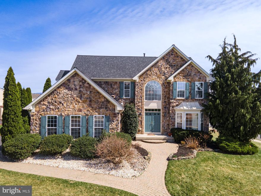 Welcome to this stunning 4-bedroom, 2 full and 2 half bath Colonial with brand NEW ROOF and newly painted, perfectly situated on a desirable corner lot and highlighted by an impressive full stone façade. A grand entrance with double doors opens into a dramatic 2-story foyer featuring a large Palladian window and elegant chandelier. Refinished Hardwood floors flow seamlessly from the foyer into the formal living and dining rooms, both enhanced by bump-out windows, crown molding, chair rails, shadow boxes, and refined baseboard trim. The beautifully updated kitchen is a chef’s dream, complete with stainless steel appliances, double wall ovens, recessed lighting, granite countertops, a double-door pantry, and an oversized center island with built-in range. Just beyond, the sunroom offers a bright and inviting space with a cathedral ceiling, skylights, and ceiling fan. The cozy family room features new wall-to-wall carpeting, recessed lighting, built-in speakers, and a gas fireplace with mantel and accent spotlights—perfect for relaxing or entertaining. A convenient laundry/mudroom and powder room complete the main level. Upstairs, double doors lead to the luxurious primary suite with new HW flooring, a vaulted ceiling, chair rails, ceiling fan, built-in speakers, a spacious walk-in closet, and a private sitting area. The en-suite bath boasts dual sinks, tile flooring, a tiled jetted corner tub, a tiled walk-in shower with glass door, and a private commode. Three additional bedrooms with new hardwood floors share a full bath with tile flooring and a tub/shower combo. The fully finished daylight basement expands your living space with updated luxury vinyl plank floors, recessed lighting, and chair rail detailing, along with a dedicated media room featuring built-in speakers and a raised platform—ideal for movie nights. A half bath adds convenience to this level. Step outside to the deck overlooking a level backyard, offering the perfect setting for outdoor entertaining or quiet relaxation. Conveniently located close to major highways US-22 and PA-33 for easy commute, Palmer Mall, Morgan Hill and Sawmill Golf Courses, shopping, restaurants and so much more!