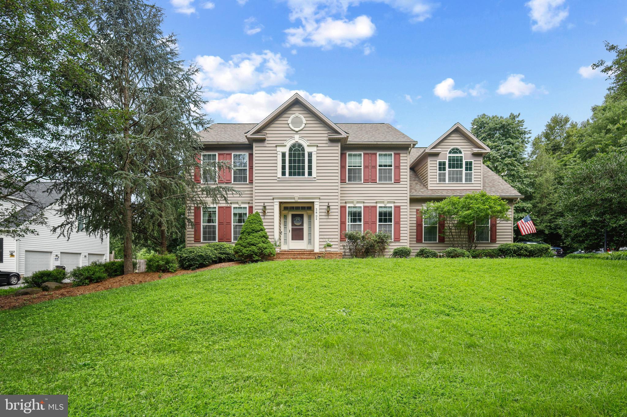 Welcome to 2802 Apple Cinnamon Place, nestled in the highly sought-after and rarely available Gingerville Woods community. This beautiful home offers privacy on a one-acre lot backing to serene forest, providing a peaceful retreat while enjoying easy access to Route 50/97 and the city of Annapolis. Step inside to a stunning two-story foyer featuring elegant interior columns, a double staircase, and gleaming hardwood floors that flow through the living and dining room and into the spacious open kitchen. The kitchen boasts solid wood cabinets, quartz countertops, a tile backsplash, and a center island, opening to a bright breakfast area and a sunken family room with a warm propane gas fireplace. A convenient mudroom with washer, dryer, utility sink, and built-in shelving connects the kitchen to the three-car side entry garage. Enjoy outdoor living on the large screened porch and deck overlooking the private backyard with a fire pit and wooded views. Upstairs, find five spacious bedrooms, including one with a soaring cathedral ceiling, and three full bathrooms. The finished basement features a large recreation area, an additional room, storage area and a sliding French door leading to the backyard. Additional highlights include a new roof, whole-house generator, and two-zone HVAC. Don’t miss this opportunity to call Gingerville Woods home—schedule your showing today!