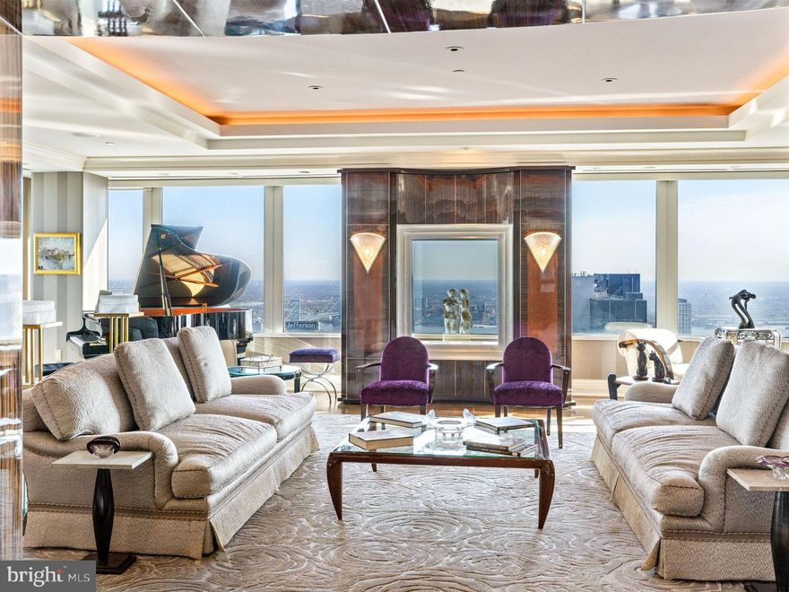 1,500-Bottle Wine Cellar in the Sky | Over 2,000 Sq Ft of Outdoor Space | Built for Entertaining. 
Perched high above the city at Two Liberty Place, this extraordinary residence offers sweeping, unobstructed views that few homes in Philadelphia can match. Expansive windows and a sprawling 2,400± square foot private terrace capture breathtaking east, west, and north-facing views, including City Hall, the Ben Franklin Bridge, the Delaware and Schuylkill Rivers, and the city skyline. Designed for seamless indoor-outdoor living, the terrace connects directly to beautifully finished entertaining spaces, creating a rare setting for both large-scale gatherings and quiet evenings above the city. The interiors were custom designed with a subtle Art Deco influence, featuring antique French fixtures, rich materials, and refined details throughout. The formal living room is anchored by a striking macassar ebony fireplace, while the spacious gourmet kitchen is as functional as it is impressive, with an oversized island designed to accommodate professional catering staff as easily as everyday cooking. Just off the kitchen, a temperature-controlled 1,500-bottle wine room and butler’s pantry make this home especially appealing for collectors and hosts alike. The private primary suite is its own retreat, complete with a dual Carrera marble bathroom, two oversized walk-in closets, and a private lounge that opens directly to the terrace for a front-row seat to the Philadelphia skyline.