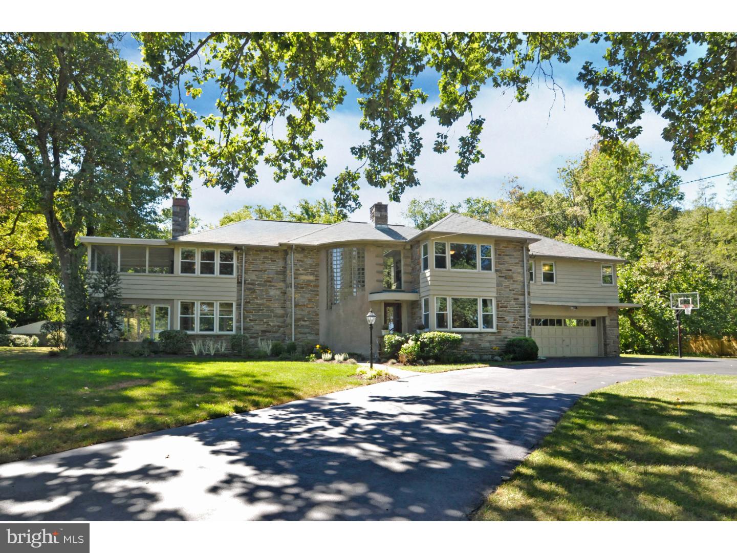Picture Perfect, 5 Bedroom home located on one of the most desirable streets in Wyndmoor, beautifully situated on a spectacular 1.85 acre property adjoining a 16 acre nature preserve. This sunny inviting home features many recent upgrades throughout, including a completely updated kitchen with new quartz counters, ceramic tile floor, and all brand new KitchenAid stainless appliances. The beautifully manicured and private grounds feature a heated, fenced pool and patio perfect for entertaining. The welcoming entrance foyer features random-width, pegged hardwood floors that continue throughout the first floor, plus a curved hardwood staircase with floor-to-ceiling glass block providing natural light. The charming, sun-drenched Family Room offers a Wissahickon schist stone wall surrounding a wood-burning fireplace with an adjacent Sun Porch with walls of screened windows overlooking the beautifully manicured grounds. The cozy Living Room could also serve as an Office and features a custom built-in entertainment center, connecting Powder Room (one of 2 on the first floor) and a door accessing the rear grounds. Entertain in the spacious Dining Room featuring a wall of custom cabinets for generous storage. 2 sets of stairs provide access to the 2nd floor. An extra-large Laundry/Mud Room with included washer & dryer is adjacent to a 2nd Powder Room, easily accessed from the Pool. The 2nd floor with hardwood floors features a Master Bedroom with multiple closets opening to a 2nd screened Sun Porch providing more spectacular views of the amazing grounds, and the Master Bath is completely renovated with new tiled floor, marble counter with double porcelain sinks & soaking tub with rain-head shower. Bedrooms 2 & 3 share a Jack & Jill Bath, & Bedroom 4 has an en-suite full bath with brand new vanity counter. The 5th Bedroom could be an ideal In-Law Suite with Full Bath & 2nd staircase providing entrance directly to this room from the 1st floor. A walk-up, floored attic is accessed from Bedroom 3. The beautiful grounds include 2 patios, a stone Spring House, & a fantastic large, enclosed vegetable and flower garden, all backing to the wooded, preserved space. Other special features include a newer roof & newer high-efficiency gas furnace. Minutes from charming Chestnut Hill with excellent restaurants & shops included a new Fresh Market, public transportation and minutes from the walking trails of Valley Green. 1-Year Home Warranty included.