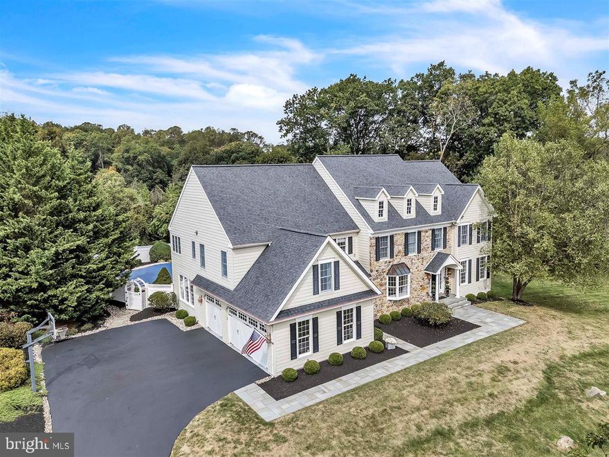 Revel in the beauty of the Chester County countryside from this absolutely breathtaking and meticulously maintained manor home, located in the sought-after community of Ludwigs Crossing. Offering 5 bedrooms, 4 full and 2 half baths,  in-ground pool, and an oversized 3-car garage, this exquisite property checks every box for luxury living. Step into the grand two-story foyer, featuring rich hardwood floors, a dramatic staircase, and stunning custom millwork that frames the entrances to the formal living and dining rooms. Natural light fills the space, highlighting the elegant architectural details found throughout both the first and second floors. The formal living room opens via French doors to a private home office overlooking the scenic rear grounds. The formal dining room boasts a tray ceiling, bay window, and adjacent butler's pantry—perfect for entertaining. Gather in the warm and inviting cathedral-ceiling family room, complete with a beautiful fieldstone fireplace with pellet stove, offering both charm and efficiency. Sliding glass doors lead to the paver patio and beautifully landscaped pool area, complete with a heated pool and hot tub—an entertainer’s dream! The heart of the home is the expansive gourmet kitchen, featuring granite countertops, abundant cabinetry, a large island with seating, and a sun-drenched breakfast area that accommodates seating for 8 or more. You'll love the convenience of the walk-in pantry and multiple storage closets located just steps away. There are two half baths on this level as well. Hardie Plank & Stone Exterior, stucco only on concrete foundation. Additional features include: New Roof in 2015,  New HVAC Systems in 2020,  Clopay garage doors, New Septic Pump 2020, New Shed 2017, Whole House Surge Protector 2024., New Pool Heater 2024. Upstairs, hardwood floors continue throughout. The spacious primary suite is a true retreat, complete with a tray ceiling, custom millwork, two large walk-in closets, a peaceful sitting area, and a spa-inspired bathroom featuring dual vanities, a soaking tub, separate shower, and private water closet. Four additional bedrooms share two well-appointed full bathrooms, including a Jack and Jill bathroom design. A full laundry room and additional storage closets complete the upper level, along with a charming reading nook overlooking the backyard through a large picture window. The finished, walk-out lower level offers incredible versatility, including a large open area for media, gaming, dining, and entertaining with a custom wet bar and a full bath. Ample unfinished space remains for storage or future customization. Be prepared to fall in love with this home. With its timeless design, thoughtful layout, and premium updates, 21 Ludwigs Crossing Lane offers a rare opportunity to enjoy refined living in a stunning countryside setting.