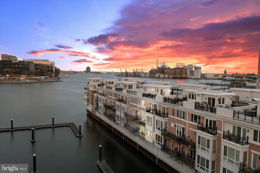 Experience refined waterfront living in the heart of downtown Baltimore, where premier shopping, dining, and entertainment are just moments away. Nestled within an exclusive gated community, this exceptional residence showcases sweeping harbor views and an unparalleled blend of elegance and comfort.  A grand double wrought iron door entry welcomes you into a stunning foyer adorned with marble flooring, intricate box and picture molding, and seamless access to both a two-car garage and a private en-suite bedroom featuring sophisticated fixtures and designer finishes.  The main living level is thoughtfully designed with an open floor plan, showcasing rich oak flooring and soaring ceilings that create a warm, inviting ambiance throughout. The living room is anchored by a gas fireplace, complemented by custom-built-in bookcases and access to one of several private balconies. The dining area is bathed in natural light and enhanced by refined millwork, integrated whole-home audio, and picturesque harbor views.  At the heart of the home, the gourmet kitchen is a chef’s dream, featuring a spacious center island with breakfast bar, 42-inch cabinetry, quartz countertops, stainless steel appliances, a butler’s bar, and a built-in buffet with open shelving, perfect for both everyday living and elegant entertaining.  Retreat to the luxurious primary suite, complete with a generous walk-in closet, sitting area, private balcony access, and a custom-built-in wardrobe. The spa-inspired en-suite bath offers a jetted soaking tub, an arabesque-tiled walk-in shower, heated floors, dual vanities, and a private water closet.  The penthouse level provides a versatile open space ideal for a home office, highlighted by a gas fireplace, along with two additional bedrooms, one with balcony access, and a well-appointed hall bath.  Additional features include a private elevator, fully renovated bathrooms, and California Closet systems throughout for optimal organization. Enjoy direct water access with private docks, perfect for boating enthusiasts.  Ideally located with convenient access to major commuter routes, including I-95, I-295, and I-83, this home offers effortless travel to Washington, D.C., New York City, and Baltimore’s most iconic destinations, including M&T Bank Stadium, Camden Yards, the National Aquarium, and beyond.  This is waterfront luxury redefined.