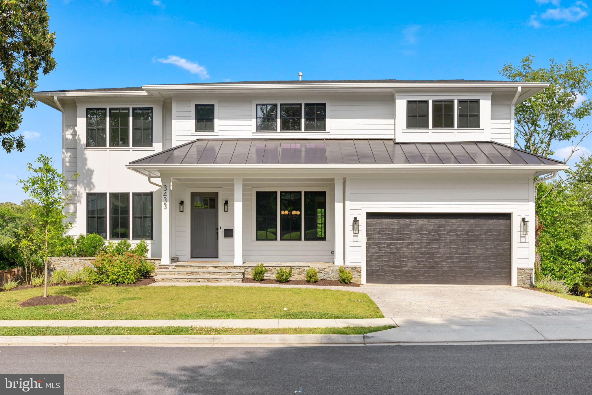 Welcome to absolute perfection inside and out at this exceptional 6BR/6.5BA modern farmhouse offering nearly 6,000 sq ft of thoughtfully designed living space on a 10,000+ sq ft lot in Arlington’s coveted Rock Spring neighborhood. Built in 2022 by acclaimed third-generation builder MR Custom Homes, this stunning residence combines timeless craftsmanship with cutting-edge amenities across 3 stories of living space that offer comfort and style to your entire household.
An inviting flagstone front porch sets the tone as you approach the home, nestled on a quiet, tree-filled street. Entering you’ll find the airy main level featuring soaring 10’ ceilings, beautiful hardwood floors, oversized windows, sophisticated finishes, and a thoughtful layout offering a seamless flow between living spaces. You’ll be greeted by a formal living room featuring charming pocket doors, an elegant dining room, and a large, sun-drenched family room with coffered ceiling, beautiful built-ins, and cozy gas fireplace. The well-lit chef’s kitchen is a true showstopper with quartz countertops, Sub-Zero and Wolf appliances, custom maple cabinetry, two Bosch dishwashers, an apron sink with Moen water filtration system, an additional prep sink, a convenient 4 gallon-per-minute pot filler, and a spacious eat-in area with built-in seating — perfect for entertaining and everyday living.
Enjoy sweeping views from the kitchen and the family room, as well as from the sizable screened porch featuring a floor-to-ceiling stone gas fireplace, infrared heaters, ceiling fan, built-in speakers, durable Trex decking, and staircase to the backyard below. From here, you can view the Fourth of July fireworks without leaving home. An elegant butler’s pantry with glass-front cabinets, bar sink, and beverage fridge connects the kitchen and dining room, while a handy walk-in pantry including a bonus refrigerator allows for ample storage. A main-level guest bedroom with en suite bathroom, mudroom, and 2-car garage with a 240V EV charger round out the first-floor conveniences.
Up a light-filled oak staircase, you’ll find a spacious sleeping level with 9’ ceilings. The luxurious primary suite boasts a beautiful tray ceiling, stunning views, dual walk-in closets, and a spa-inspired bath with oversized white marble shower, 66” soaking tub, dual vanity, heated floors, and Toto Washlet. Three additional generously sized bedrooms — two with walk-in closets — plus a well-appointed laundry room with sink and folding space complete the upper level.
Enjoy entertaining on the walkout lower level featuring 9’ ceilings, a fully equipped home theater with tiered seating, a stylish walk-behind bar with ice maker and beverage fridge, and a huge recreation room with space for comfortable couches and a table for family game night, plus French doors leading to the backyard. This level also boasts a guest suite with ensuite bath and walk-in closet, a gym with a mirrored wall, barre, and rubberized flooring, and a sizable storage room with built-in shelving.
Smart home upgrades include a custom whole-home Eero mesh Wi-Fi system and a 4-amp SONOS A/V system integrated across seven rooms, as well as a EMTEK front door keypad, mobile app-controlled garage door, app-controlled two zone thermostat with humidifier and air cleaner, and Ring camera/doorbell. Environmental features include the 240V EV outlet, eco-friendly paver driveway and front walkway, native plant landscaping, and double-paned high performance Low-E glass windows.
Ideally located in the desirable Discovery/Williamsburg/Yorktown school pyramid. Highly walkable, picturesque neighborhood situated a mere 4 traffic lights from Chain Bridge. Enjoy quick access to DC, Ballston, two Metro stations, I-66, I-495, and both Reagan and Dulles airports. Whether you’re seeking an entertainer’s dream or a luxurious private retreat, don’t miss the opportunity to make this delightful and near-new home your own!