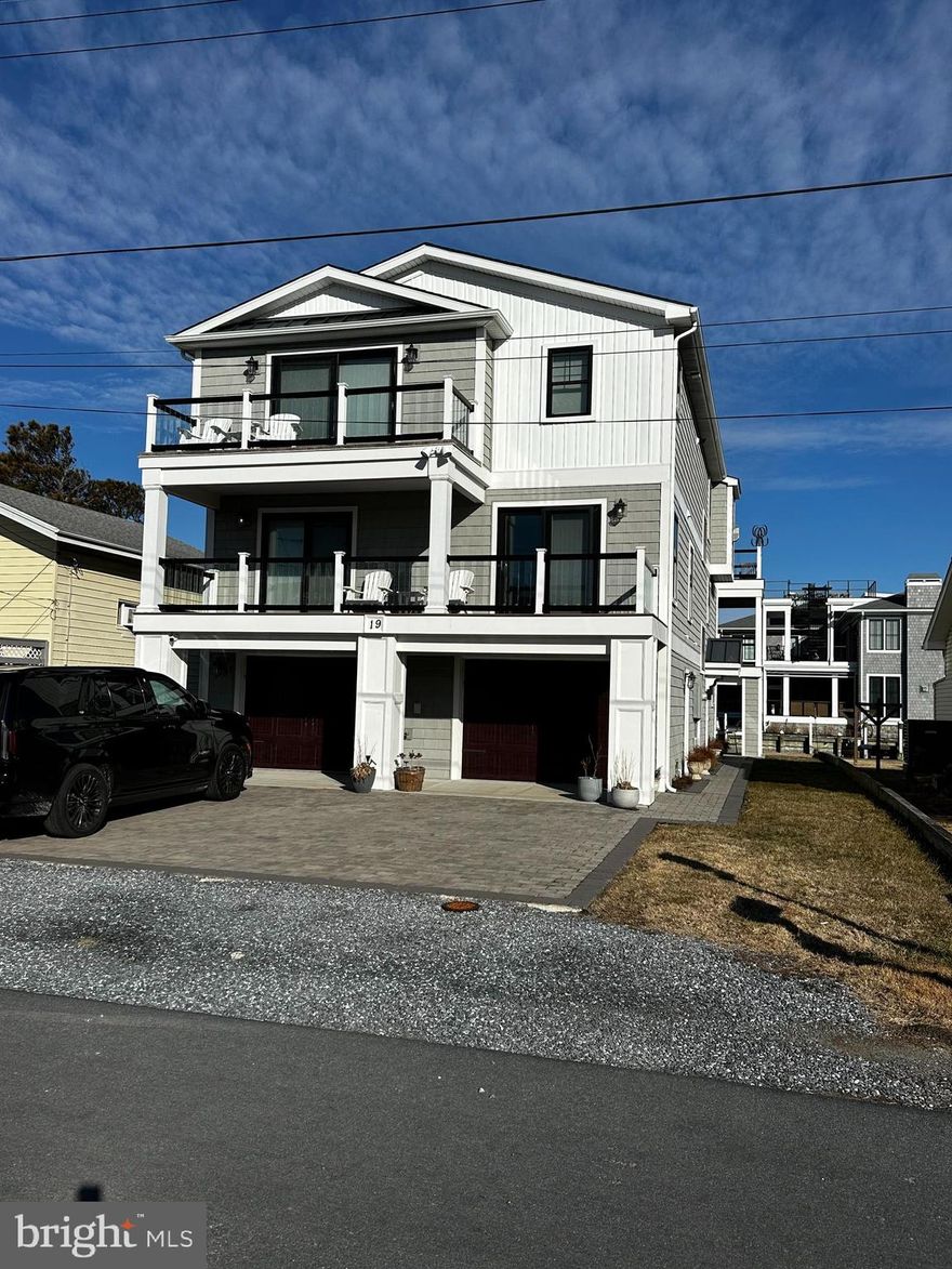 Additional photos coming soon.
Exceptional luxury waterfront residence featuring 4 bedrooms and 3.5 baths, custom built in 2018 with enduring quality and timeless design. Every detail was thoughtfully curated to deliver refined coastal living with modern convenience. An oversized, climate-ready garage offers space for up to three vehicles  and provides direct interior access, along with a ground-level main entrance on the east side.
The ground level is designed for both function and lifestyle, offering a private fitness studio, elevator access, and an expansive, walk-in storage area that replaces a traditional attic—without stairs. This level opens seamlessly to the rear yard and wide canal, allowing for effortless boat-to-home access after a day on the water.
Throughout the upper levels, custom-crafted finishes elevate the home, including custom tile flooring accented by oak stair treads and landings. A sophisticated billiard and entertaining room features a full wet bar (pool table does not convey), creating a perfect space for hosting guests.
The gourmet kitchen and spa-inspired baths are finished with quartz and granite countertops. The kitchen is equipped with premium stainless-steel appliances, including a six-burner gas range and a dual-zoned 180-bottle wine refrigerator—an ideal setting for both casual meals and elevated entertaining.
The living room showcases an oversized fireplace propane fireplace, custom ceiling fan, and large-format television, opening to a rear deck and screened porch with tranquil canal views. A spiral staircase leads to a private rooftop deck, offering panoramic coastal vistas and unforgettable sunsets.
Ideally located just 1.5 blocks from the beach, this extraordinary waterfront home delivers the perfect blend of luxury, comfort, and coastal lifestyle.