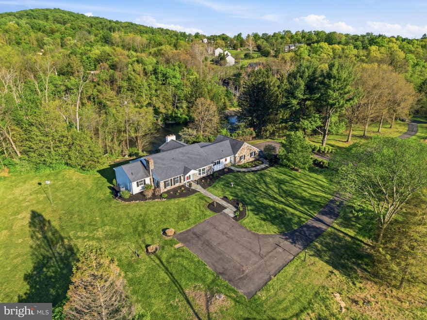 An incomparable hilltop setting with panoramic pond views sets the stage for this custom raised rancher built by Paul Kutz, offering 4,900+ sq ft of finished living space, 5 bedrooms, and more than an acre of beautifully positioned land. Designed with entertaining in mind, the home features incredible flow throughout, oversized living spaces, expansive gathering areas, first floor office and large windows that fill the home with natural light while capturing breathtaking views of the surrounding landscape and water. Thoughtful updates over the years include a beautifully remodeled primary bathroom, remodeled great room, rebuilt patio, hardwood flooring, and improved outdoor hardscaping. Generous room sizes, abundant storage, a cozy wine cellar, and additional recreation spaces add to the home’s unique character and versatility. The rebuilt outdoor patio offers the perfect place to relax, entertain, and enjoy the stunning hilltop scenery overlooking the pond. Despite its peaceful and private setting, the property is located just minutes from Route 422, Philadelphia Premium Outlets, local parks, shopping, dining, and everyday conveniences. A truly rare opportunity offering space, scenery, privacy, and convenience all in one remarkable property.