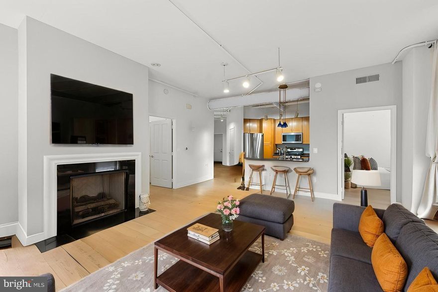 Welcome to Your Sunlit Corner Sanctuary! This radiant 2 bed/ 2 bath condo is ideally located just steps from Whole Foods, boutique shops, top-tier gyms, Starbucks, and an array of dining options. Enjoy your morning coffee on the private balcony or cozy up by the gas fireplace in the open-concept living space, where soft-toned wood floors enhance the warm, inviting ambiance. Brand new flooring in the main living area, kitchen and foyer! The corner kitchen boasts stainless steel appliances (New dishwasher and microwave!), granite countertops, and recent upgrades designed for effortless entertaining. A brand-new HVAC system was installed in April 2025, ensuring year-round comfort. Freshly painted and thoughtfully updated with stylish new vanity lights, the spa-like master bathroom features a luxurious whirlpool soaking tub and a separate standing shower—your personal oasis. Both bedrooms are of generous size and have walk-in closets! New stackable washer/dyer in unit! Right across from the elevator for extra convenience. Pet-friendly condo with amenities like a huge outdoor pool, gym, and party room. This home also includes one garage parking space .  Can rent 2nd parking spot for as low as $40/mo. Access to a shuttle to the metro, with quick connections to I-66, Dulles Airport, Fairfax County Parkway, Route 50, and Route 29. Modern comfort meets timeless style—your dream home awaits!