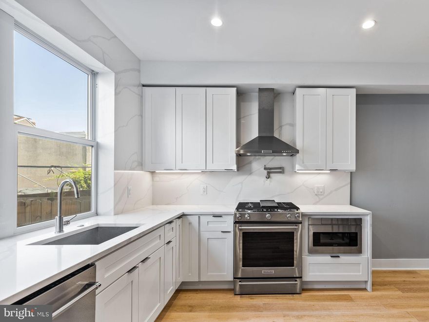 Introducing 2227 League Street! This modern row home impresses immediately. Enter to hardwood floors, soaring ceilings, and a raised kitchen and dining area that creates delineated spaces for living and dining. Upgraded kitchen with white shaker cabinets, stainless appliances, and quartz backsplash to compliment the countertop. Range hood over the oven. Microwave built-in to the cabinet. Floating stairs rise to the second level with two amply apportioned bedrooms bifurcated by a full bath with shower/tub. Tastefully modern bathroom fixtures and vanity. Of course, the challenge in every Philadelphia row home is bringing natural light from the front and back into the heart of the home. This home addresses that challenge with glass enclosed stairwells on the second and third floor. Even better, an upgraded kitchenette wet bar awaits at the top of the third floor landing. Perfect for entertaining on the roof deck. Even better for the coffee pot as it's conveniently situated outside the primary bedroom suite. Impressive primary bedroom with ample natural light, custom closets sufficient for most, and an upgraded bathroom with double, floating vanity, soaking tub, and spa-like shower. Roof deck offers unobstructed Center City views. Don't miss the daylighted basement with large windows creating a cozy den. Private, full bath in basement for convenience of main level guests as well. Enjoy Graduate Hospital living here. A short walk to all the neighborhood amenities. Approximately seven (7) years remaining on the property tax abatement. +++ Property tax amount in listing does not yet reflect tax abatement. Approval documents in additional listing documents. +++