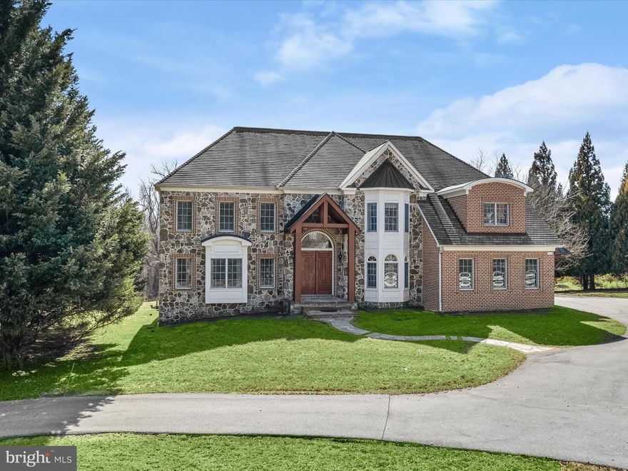 Introducing this magnificent five bedroom home, offering six full and two half bathrooms, set on a lush 1.02-acre lot backing to woods. As you arrive, a covered portico and grand double wood doors welcome you inside into a two-story foyer, where rich hardwood floors with inlay borders set the stage for exquisite craftsmanship. Arched doorways, stately columns, and soaring ceilings create a timeless elegance, while oversized windows bathe the interiors in natural light. Refined details, including intricate crown molding, chair rail accents, and classic wainscoting, enhance every space with ceiling speakers throughout the home. The formal living room, framed by majestic columns, offers a sophisticated lounge area, while the dining room provides an elegant setting for memorable gatherings. A butler’s pantry with a sink and beverage fridge connects seamlessly to the gourmet kitchen, making entertaining effortless. The kitchen impresses with granite countertops, a tile backsplash, and 42” cabinetry with underlighting and a pull-out pantry. High-end appliances include a Thermador® six-burner gas rangetop with griddle, built-in range hood and pot filler, a Viking® refrigerator/freezer, a Viking® double wall oven, a Bosch® dishwasher, and an ice maker. On the other side of the kitchen, the mudroom provides access to the garage and features extra storage cabinets, a Sub-Zero® freezer, a laundry room with granite counters and a sink, and a convenient half bathroom. Enjoy casual meals in the breakfast room that is bathed in natural light from skylights and sliding glass doors leading to the backyard. At the heart of the home, the grand family room captivates with a soaring 20-foot ceiling, a cozy wood-burning fireplace, and expansive windows that frame picturesque views. A main-level bedroom with an en-suite bathroom currently serves as a private office but is equally suited for a guest suite. Ascend to the second level, where two Juliet balconies overlook the family room. The lavish primary bedroom suite boasts a 10-foot tray ceiling and an expansive walk-in closet. A graceful archway leads to a private sitting room, ideal for morning coffee or a quiet retreat. The spa-like primary bathroom highlights a jetted tub, a dual vanity, a water closet, and a luxurious walk-in shower with a bench. Three additional bedroom suites on this level feature tray and coffered ceilings, bay windows, walk-in closets, and private en-suite bathrooms. Designed for entertainment and relaxation, the expansive lower level offers endless possibilities. A massive recreation room accommodates a pool table and additional lounge space, while a versatile bonus room behind French doors is perfect for a home gym. Host unforgettable movie nights or watch the big game in the theater, where tiered seating ensures every guest has the best view. A wine cellar with a CellarCool® system, a full bathroom, and a spacious utility room with ample storage complete this level, along with convenient walk-out stairs. Beyond the main home, a separate backyard studio with a half bathroom offers endless possibilities. Whether used as a home office, creative workspace, or guest retreat, this flexible space includes its own heating, cooling, and water heater for maximum comfort. Modern conveniences abound, including an oversized garage with two Tesla® EV chargers, energy-efficient triple-zoned heating and cooling, three 75-gallon water heaters, a central vacuum system, and a security system with cameras. Owned solar panels and two generators provide additional efficiency and peace of mind. A security gate enhances the privacy of the shared driveway, completing this unparalleled luxury residence. Some images have been virtually staged.