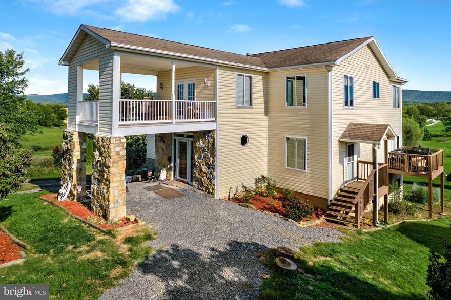 An outstanding living experience is waiting for you at this beautiful home in Charles Town, WV.  Nestled on a spacious 13 acre lot, this 4 bed, 5 bath residence offers more than 3200 sq ft of living space and an additional 1800 sq ft of unfinished space that offers the potential to expand the finished living area to over 5000 sq ft.  This property was carefully designed and built to take full advantage of the gorgeous rolling hills that surround it. Large windows perfectly frame the picturesque surroundings, while multiple decks allow you to sit and relax and enjoy either the sunrise or sunset as you enjoy the wonderful fresh air.  There is wildlife galore—deer, rabbits, turkeys, and songbirds.  The 13 acres allow homesteaders to farm crops or raise livestock.  There is a livestock pen with a 15'x30' run-in ready for animals.   Pen is approximately 2,500 sqft and has two trees that help shade livestock while the eastern and southern sides are insulated by vines and has easy access from easement road (Windy Valley Lane).  On the property you will also find two orchards with fruit producing pear and apple trees.  Keep chickens in the large, insulated luxury coop that offers heating/cooling, a roosting bar, two nesting boxes, and ramp to a large, shaded run that offers protection from predatory birds. The seller is willing to include a "starter pack" of poultry.  A pond, unfinished in-law quarters, and heated storage complete the package.   There are two wells on the property and a commerical grade geo-thermal heating/cooling system.  Historic schoolhouse steeped in Virginia/West Virginia history that can be renovated to be in-law suite, storefront, etc.  The schoolhouse urrently has running water, bathroom, refrigerator, and power. Inside the main home you will discover newly installed composite wood flooring on the main level. Windows are everywhere, ensuring that the lovely scenery is always just a glance away. A wood stove in your family room provides abundant heat on a chilly winter night. Your kitchen boasts an immense amount of room, with plentiful cabinet storage and an eat-in area with panoramic views of the Shenandoah mountains. Your master suite is the perfect place to retire at the end of a long day, and offers an oversized jetted soaking tub that will relax away the stress of the day.  
On top of all this, the location simply can’t be beat. You will love being just over an hour from Washington, DC and 50 minutes from Washington Dulles International Airport!