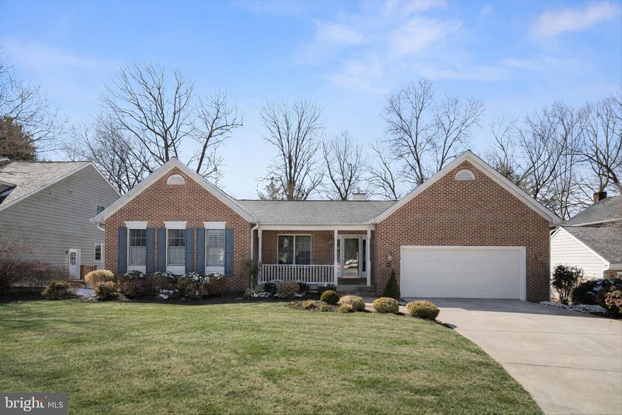 At the end of a quiet cul-de-sac in sought-after 10623 Millet Seed Hill, this exceptional residence showcases a timeless façade, inviting covered front porch, and a two-car front-loading garage, setting the tone for the warmth and refinement within.

The foyer welcomes you with rich hardwood flooring that continues throughout the main living areas. Just beyond, the sunken living room creates architectural distinction while maintaining an open, connected feel. Anchored by a striking stone double-sided gas fireplace installed in 2016, the space is filled with natural light and features glass doors that lead directly to the elevated deck, seamlessly blending indoor and outdoor living. The dining room, also finished in hardwood, shares the fireplace’s ambiance and offers an elegant setting for formal gatherings with effortless flow to the kitchen.

Renovated in 2003, the kitchen features ceramic tile flooring, a rare double-island layout, and more than 100 square feet of granite countertop space, offering exceptional prep and gathering areas. Premium GE Monogram appliances—including a refrigerator, double ovens, gas cooktop, and wine refrigerator—deliver professional-level performance, while a heatilator adds warmth and character as the space opens to casual dining and family areas.

The primary suite serves as a true retreat, complete with plush carpeting, a vaulted ceiling that enhances scale and light, and a private glass door providing direct access to the deck. A spacious walk-in closet offers abundant storage, and the en-suite bath, finished in ceramic tile, features spa-inspired finishes designed for relaxation. An additional upgraded en-suite bedroom on the main level provides ideal flexibility for guests or convenient single-level living, and a beautifully renovated powder room completes the main level.

The fully finished walk-out lower level expands the home’s versatility with a generous carpeted recreation area and adjoining game room ideal for entertaining. The dedicated theater room, completed in 2019, spans approximately 570 square feet and features a Sony 85-inch 4K HDTV with a seven-speaker (5.2) surround sound system for a true cinematic experience. An additional lower-level en-suite bedroom offers excellent accommodation for guests or extended stays, while a substantial carpeted flex room with walk-out access provides endless possibilities for a home office, fitness space, or additional lounge area.

Outdoor living is equally impressive. The elevated dining deck, accessed through glass doors from the living room and primary suite, creates the perfect setting for al fresco meals and sunset gatherings. Below, the covered patio offers shaded relaxation, and the hot tub provides a private, spa-like retreat surrounded by mature landscaping.

Located within the vibrant Columbia community, residents enjoy access to a community in-ground pool, scenic walking trails, and the convenience of walking to grocery stores, dining, and everyday essentials—along with the extensive amenities and lifestyle offerings that make Columbia one of the most desirable places to live.