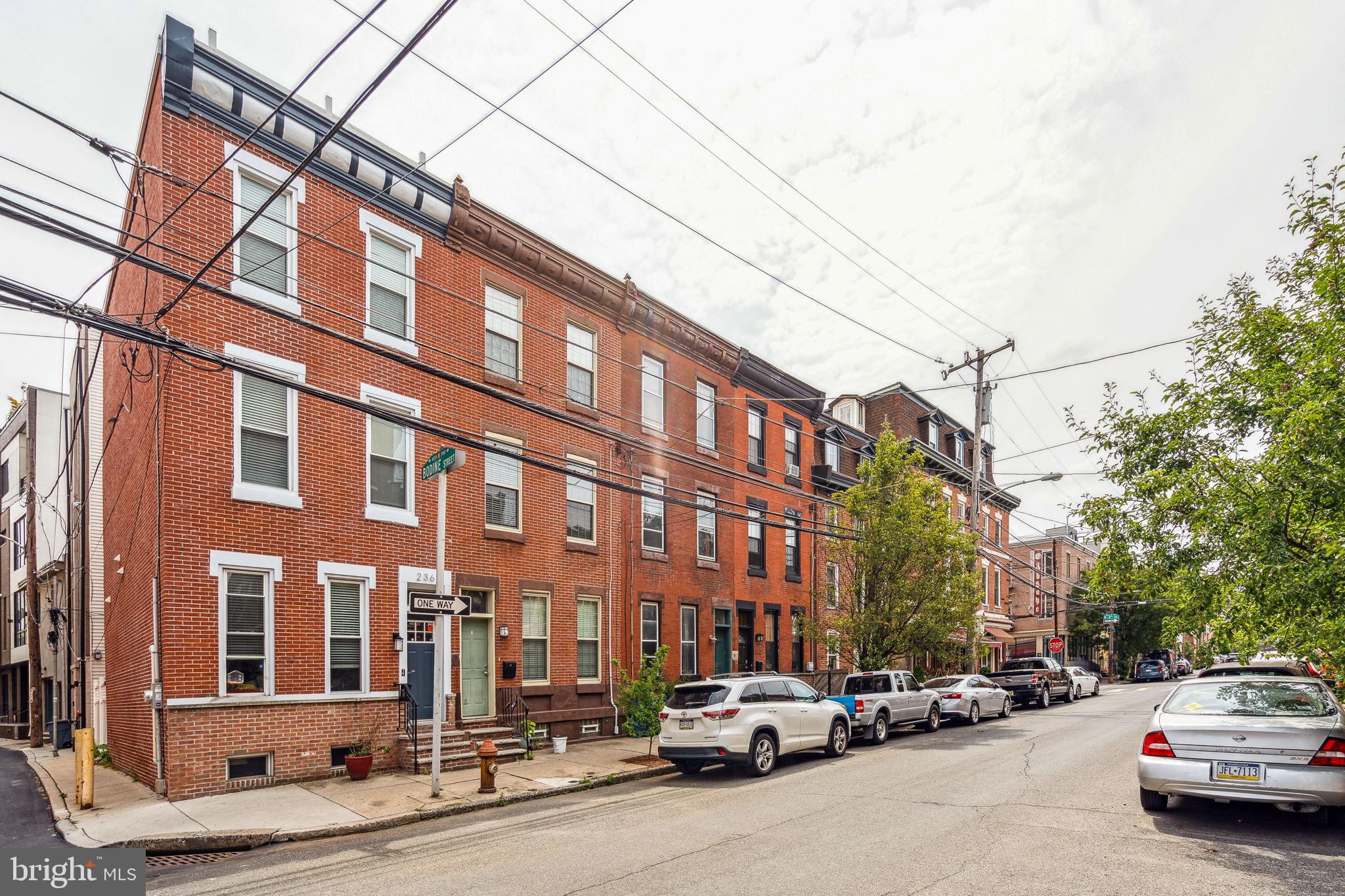 Seller relocating!! Welcome to 240 Fairmount Avenue! This beautiful 4 bedroom, 2 bathroom home is situated in the vibrant Northern Liberties neighborhood. This townhome offers a backyard, rooftop deck, and fully finished basement! A brick exterior welcomes you into a cozy vestibule adorned with a timeless chandelier and custom-painted wallpaper. Step inside to discover an abundance of natural light streaming through two oversized windows, illuminating the original hardwood floors that span the open living and dining areas. With ceilings reaching over 10 feet, recessed lighting, and a gas fireplace, this spacious and airy setting showcases bespoke elements like built-in shelves, intricate millwork, and an elegant staircase. The sleek and contemporary kitchen features a monochromatic design with white shaker-style cabinets, stainless steel appliances, white quartz countertops, and subway tile backsplash. Outside, a shared patio offers a delightful space for gatherings with loved ones on pleasant days. For year-round entertaining, the stunning finished basement  boasts custom details such as exposed beams, a built-in pantry, wood bar, and a built-in desk with storage for those who work from home. This level also includes a full bathroom with a marble shower floor, as well as a tiled laundry area with ample storage space. At the heart of the second level, you'll find a bright full bathroom adorned with marble floors, a spacious vanity, wainscoting, and a reclaimed door. Original hardwood floors extend throughout the upper levels, encompassing a generously sized bedroom at the rear and a large bedroom at the front with two grand windows and a walk-in closet. The third level of the home accommodates two additional spacious bedrooms. Completing the picture is a brand new deck on the third floor, providing an ideal space for entertaining. Not only is 240 Fairmount an exceptional residence, but its location in Northern Liberties is a paradise for walkers! Nearby, 2nd Street is lined with beloved neighborhood establishments like Dolce & Caffè, The Kettle Black bakery, Freedom Apothecary, North Bowl, and Standard Tap along with fitness centers OrangeTheory and City Fitness. This location also offers easy access to I-95 and I-676. Schedule your showing today!