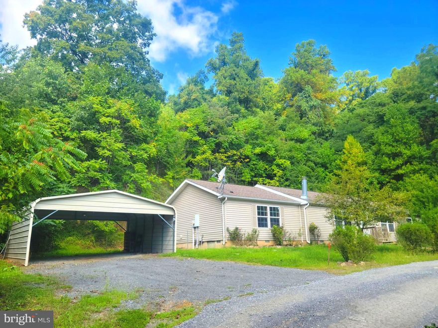 Do you want a home in the privacy of a rural setting, but don't want to actually be far from modern conveniences and commuter routes? Do you crave the peace and tranquility of country living, but still want DoorDash to be able to find you when you don't quite feel like making dinner?  Believe it or not, that compromise DOES exist! Welcome to 261 Miracle lane, a recently-refreshed, MOVE-IN-READY, doublewide on a permanent foundation that offers total sanctuary from the hustle-and-bustle that is surprisingly not that far away. Situated in the west end of Martinsburg, just a few miles from I-81 at Exit 13, this home will basically enable you to feel like you're fast-forwarding your commute between city life and country life. Don't LIVE where you work, live in a retreat that's just hidden unexpectedly CLOSE to where you work. When you're not outside drinking in the relative silence of your dead-end country road, step inside where you can enjoy the floor plan that features a massive kitchen with island, an owner's suite with with a separate tub and shower and dual vanities, and a split-bedroom design in which all the bedrooms have walk-in closets. Come have all of this, on just over 2 acres, for way under $250k. What's not to love? IF YOU LIKE WHAT YOU SEE, CALL        !!!!!!!!!