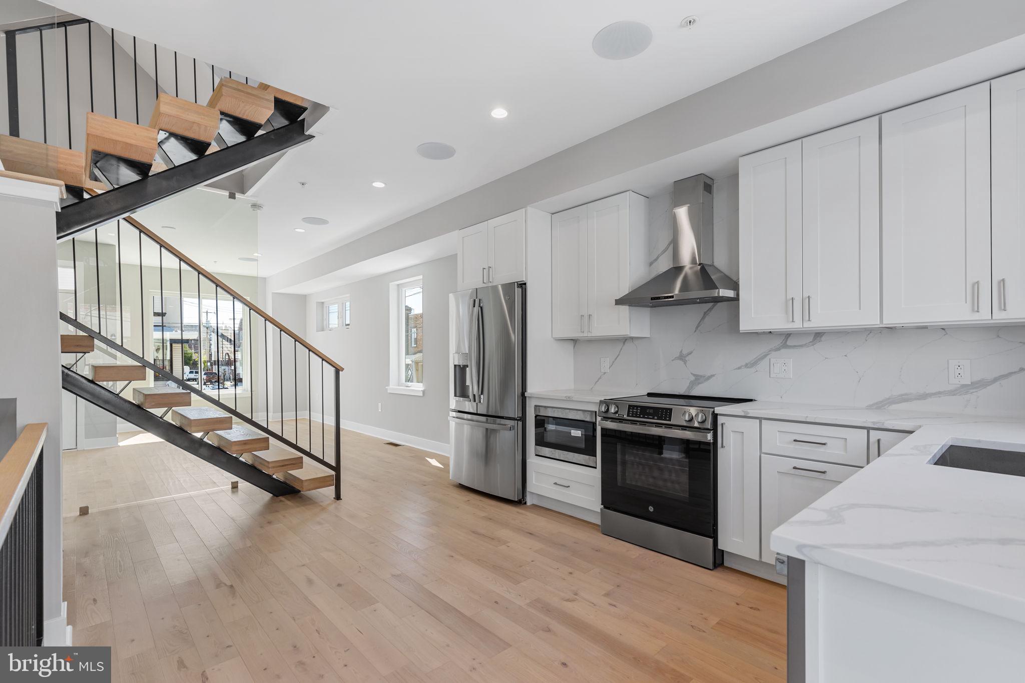 Garage parking. Tax abatement. Stunning roof deck views. Only three (3) homes remaining to purchase on this impressive block in Grays Ferry! Enter this modern row home to an impressive main level with living and dining areas bifurcated by a central staircase. Modern kitchen with white shaker, soft-close cabinets, quartz countertops, and stainless steel appliances. Elevated and private rear patio off the kitchen, perfect for grilling or better ventilating the kitchen when cooking! On the second floor, both bedrooms impress immediately with oversized windows and amply apportioned closets. Laundry on the second floor for convenience. Double vanity and upgraded shower/tub in second floor bathroom distinguishes from the typical new construction home. The third floor is home to the primary bedroom suite. Wet bar at center which is perfect for making coffee in the morning or roof deck cocktails in the evening. Walk-in shower and soaking tub. Double vanity. Impressive primary bedroom with oversized closet and plenty of room for a king sized bed. Center City views on the roof deck with water and electric access for plants and entertainment. Don't miss the rear entry garage and half bath on the lower level. Lots of additional storage space in the garage. It's bigger than most. Convenient to University City, Graduate Hospital, I-76, and Center City Philadelphia. Expected completion in Early 2025. Still time for buyer to customize interior finishes. Schedule your private tour today! (Listing photographs from completed model home. Upgrades visible in photos. For upgrade pricing, see additional documents.)