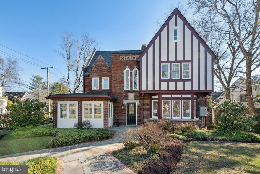 Gracing a lovely corner lot, this prominent Forest Hills Tudor has just undergone a comprehensive renovation and expansion resulting in four dazzling light-filled levels and all new systems (HVAC/Electric/Plumbing)! The Harlequin-pattern marble entry foyer, grand staircase, original lead glass windows, wrought iron railing, impressive ceiling work, well-placed niches, gorgeous light fixtures, abundant windows, and rich hardwood flooring set a very special tone. Offering an open, yet defined floor plan, the main level has it all: large airy living room with stunning diamond-cut bay window and built-ins, elegant dining room with box beam coffered ceiling, vibrant corner office with walls of windows, a show-stopping center island chef’s kitchen with Calacatta Gold Storm quartz countertops, Thermador appliances and a window seat, an adjacent family room with exposed brick archways and glass door access to the side patio, and a darling powder room. Second level highlights include two beautiful primary suites (one with two walk-in closets), a very spacious third bedroom, and three stylishly renovated baths. At the top, the third level features a phenomenal bedroom with exposed beam ceiling, a bonus/play room, two walk-in closets, and a gorgeous new bath. Walkout lower level offerings include a nice recreation room/fifth bedroom, the fifth full bath, a laundry room with sleek front-loading GE appliances and a laundry tub, and access to the two-car garage. Outside, a wrought iron fence fully encircles the verdant grounds which offer beautiful specimen plantings, plentiful green space, and a delightful English patio. Welcome home!