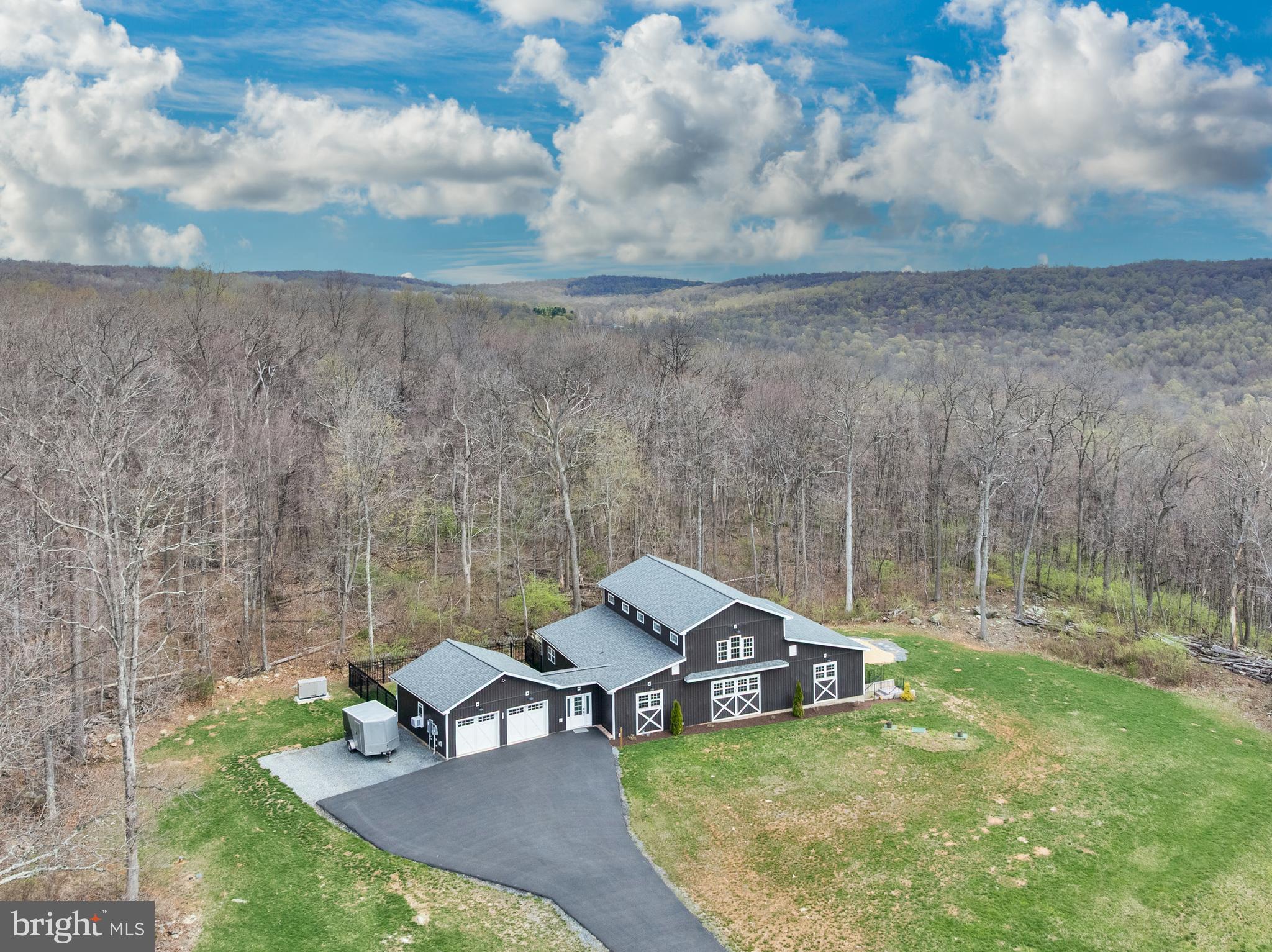 Welcome home to this custom-built, one-of-a-kind barndominium on over 3.5 acres on the Frederick County side of Smithsburg! This dreamy barn style farmhouse features open concept main level living with three bedrooms, two and half bathrooms, a massive great room with beautiful vaulted tin ceilings and custom repurposed wood cross beams. Abundant natural light with many upper level windows and gleaming hardwood floors. Rustic shiplap walls throughout the main living area, fresh paint in the bedrooms and laundry room, plus new carpet throughout. Oversized kitchen with tons of counter space, chef's stove, and beautiful granite countertops. A primary suite with ensuite full bath and large soaking tub. A laundry room that dreams are made of, plus a full unfinished basement ready for your personal touch! It doesn't stop there with heated floors in both full baths and a covered porch for additional living space, perfect for enjoying your morning coffee. Gas fireplace with thermostat, whole house sprinkler system and an oversized attached two car garage with cabinets. This home has it all! Move in with peace of mind with a newly paved driveway, propane whole house generator, new roof, and a new clothes washer. Enjoy your private oasis tucked in a wooded lot with mature trees! Schedule your private tour today before it's too late!