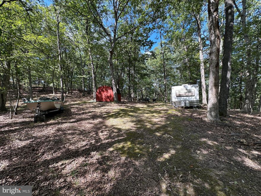FULLY FUNCTIONAL.....5 WOODED ACRES WITH WELL, SEPTIC & ELECTRIC IN PLACE AND READY FOR YOUR RV OR HOME. IF YOU WERE STARTING FROM SCRATCH, IT WOULD COST YOU AT LEAST 35K TO INSTALL THE INFRASTRUCTURE THAT'S ALREADY IN PLACE....IN THEORY YOU'RE ONLY PAYING 15K FOR 5 ACRES! CAMP, HUNT, SHOOT OR BUILD....NICE EAST FACING VIEW OF ROMNEY MOUNTAIN. IT COMES JUST LIKE YOU SEE IT, WHETHER YOU WANT IT OR NOT....CAMPER, BOAT & CONTENTS OF SHED NEED TO BE TRASHED BUT THAT'S BEEN FACTORED INTO THE PRICE. CONVENIENT COUNTRY LOCATION, ONLY 1 MILE OFF THE PAVED ROAD, 2 MILES FROM PUBLIC ACCESS ON THE SOUTH BRANCH OF THE POTOMAC RIVER & PUBLIC HUNTING AND 4 MILES FROM DOWNTOWN ROMNEY. WOULD MAKE AN EXCELLENT HOME BASE FOR RV FOLKS. WHERE ARE YOU GONNA FIND 5 ACRES WITH ALL THE UTILITIES IN PLACE FOR UNDER 50K WITHIN 2.5 HOURS OF DC? NOWHERE BUT HERE!