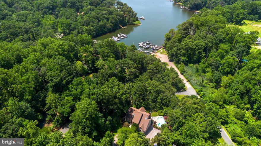 Welcome to this exceptional Stone & Cedar Home with a saltwater pool and water views in Severn View! Nestled on 1.42 wooded acres, this stunning contemporary home offers a rare combination of privacy, luxury, and water privileged living in the highly sought-after Severn View community. With breathtaking seasonal views of the Severn River across Asquith Creek, this 6-bedroom, 5-bathroom residence spans across three levels and is designed to impress. Upon entering through the grand two-story foyer, you're greeted by an open, airy layout with Brazilian walnut floors and abundant natural light. The spacious formal living and dining areas flow seamlessly into the recently remodeled gourmet kitchen (2016), featuring crisp white cabinetry, quartz countertops, a large island with seating, and top-tier appliances—ideal for any home chef. The adjoining family room, with its cozy wood-burning fireplace, offers a relaxing space to unwind. Step outside onto the expansive rear deck, accessible from both the dining and family rooms, where you can enjoy serene views of the saltwater pool, waterfall feature, and Asquith Creek. This is the perfect spot for entertaining or simply taking in the peaceful surroundings. The main floor also includes a versatile guest suite, currently used as a home office, along with a full bath—providing flexibility for family and guests. Upstairs, the primary suite is a true retreat. It boasts a private stone fireplace, a private balcony with stunning water views, and a beautifully renovated spa-like bathroom complete with a freestanding soaking tub, dual vanities, a walk-in shower, and an expansive walk-in closet. Three additional generously sized bedrooms and two full baths complete the upper level, ensuring ample space for family and guests. The finished lower level is an entertainer’s paradise. With direct access to the pool area, it includes a kitchenette, bedroom/exercise room, office, full bath, and a large recreational room—ideal for games, movies, or hobbies. The walk-out basement also provides easy access to the private backyard oasis and the secluded pool area. Additional highlights include a 3-car garage with soaring ceilings for maximum storage, a circular driveway, a playground area adjacent to the pool deck, and attic and crawl space storage. The community offers a wealth of amenities, including a newly renovated, gated waterfront with a pavilion, firepit, kayak storage, a boat ramp, piers, and your own deeded boat slip (#3) at the nearby marina. With award-winning schools, proximity to the B&A bike trail, and easy access to major commuter routes, this home combines luxury, comfort, and convenience in one extraordinary setting. Don’t miss the opportunity to make this rare property your own—schedule your private tour today!
