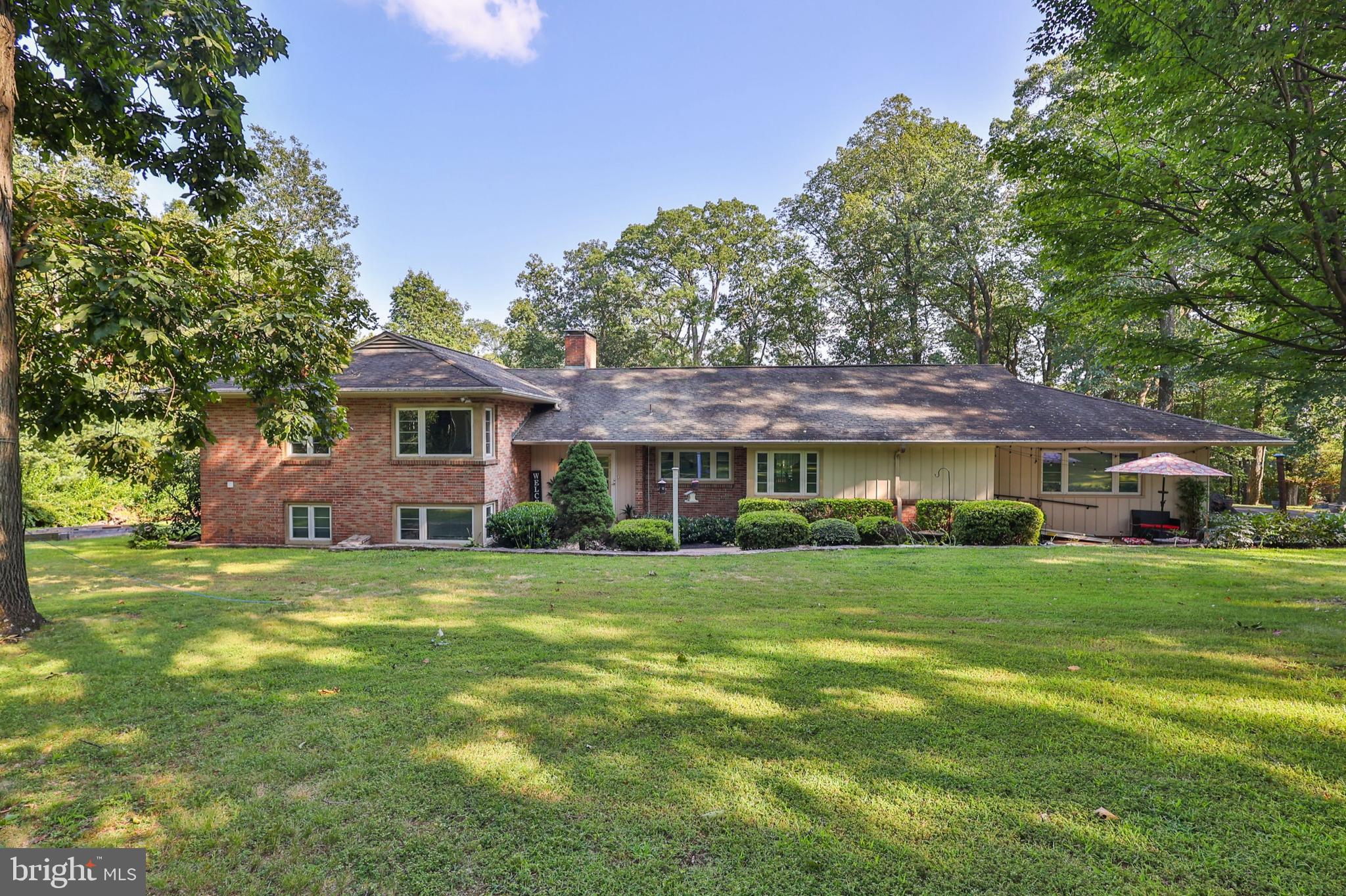 This gorgeous Bucks County home sits on a 2.7-acre park-like property in East Rockhill Township, offering complete privacy with open lawn areas and a tile patio overlooking the in-ground pool. The updated eat-in kitchen includes stainless steel appliances, a breakfast bar, and plenty of cabinet space, while the formal dining room flows into a cozy family room with a fireplace. Upstairs, the primary suite features a walk-in closet, a cedar closet, and an en-suite tile bathroom. The upper level also has two additional bedrooms with hardwood floors, sharing a beautifully updated full bathroom. The lower level boasts a two-room suite, a spacious family area with a fireplace, a laundry room, a kitchenette, and a private entrance—perfect for extended family or guests. The finished basement offers versatile space to suit your needs. This home is a fantastic option in a prime location! Conveniently located across the street from 69 Acre Markey Park with walking trails, baseball fields and picnic pavilions, and close to Pennridge schools!