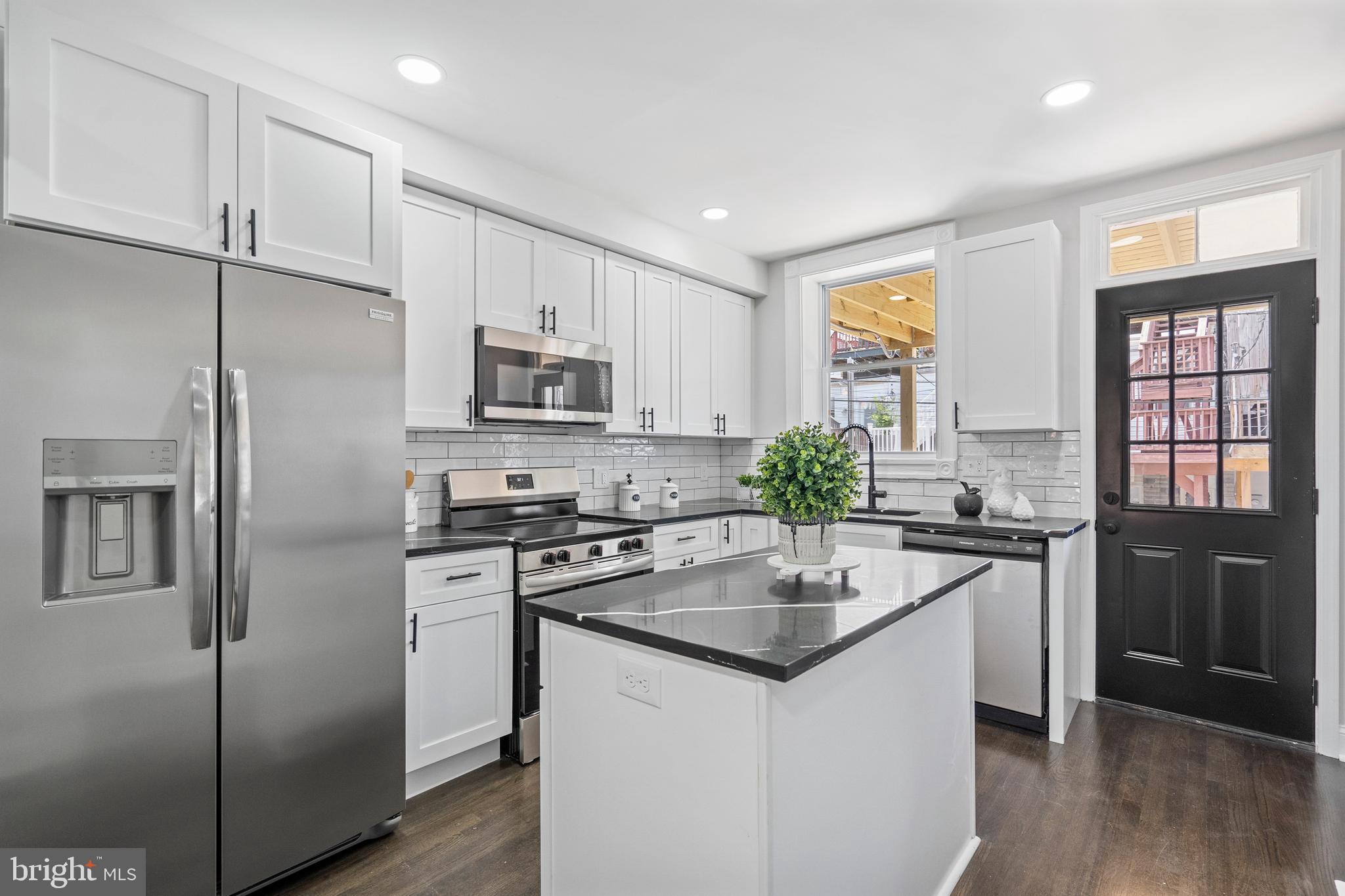 Stunning CHAP Renovation in the Heart of Canton! This fully renovated gem offers the perfect blend of charm, functionality, and location—complete with 10-Year CHAP Tax Credit approval saving you about $650 per month! Step inside to beautifully refinished hardwood floors that flow throughout a bright and open floor plan. The spacious living room is ideal for entertaining, while the adjoining dining area opens seamlessly to a chef's kitchen featuring quartz countertops, stainless steel appliances, a tile backsplash, ample cabinetry, and a center island for casual dining. Upstairs, the spacious primary suite is a true retreat with dual closets and a luxurious ensuite bath boasting double vanities and a large walk-in shower. A second bedroom and full bath with a tub/shower combo complete the level, along with access to both a second-story deck and a rooftop deck showcasing panoramic views of Patterson Park, the iconic Natty Boh Tower, the Inner Harbor, and Downtown Baltimore. The fully finished lower level offers two additional bedrooms, a full bath, laundry area, and extra storage—plus direct access from the rear private parking pad for added privacy and convenience. Just 3 blocks to Patterson Park and Canton Square, and moments from Canton Crossing and all the vibrant shops and restaurants the neighborhood is known for. Don’t miss your chance to own this thoughtfully renovated home in one of Baltimore’s most sought-after neighborhoods!
