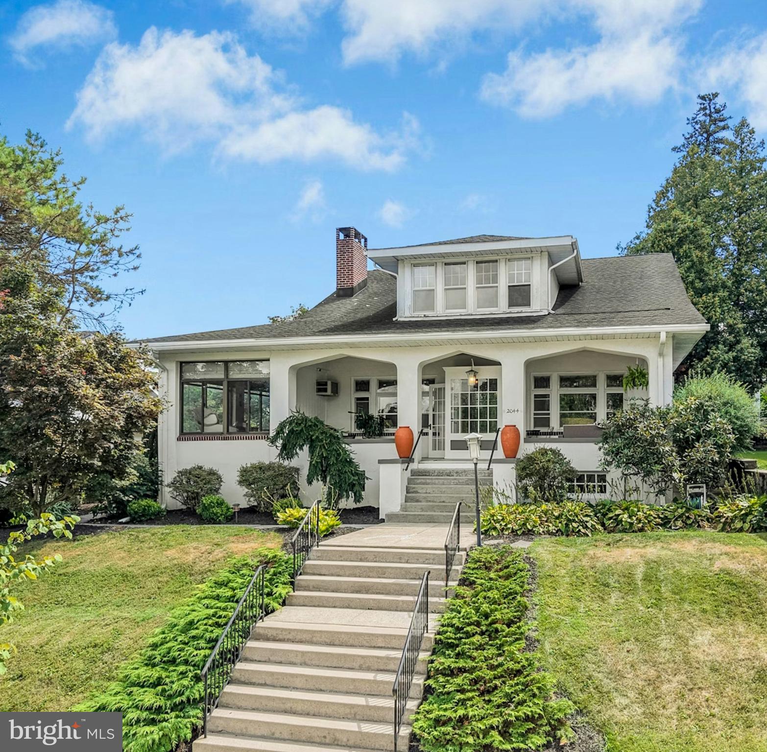 A tree-lined street in a thoroughly charming neighborhood is the setting for this historic craftsman bungalow in the deep west end of Allentown. Built circa 1921, the residence has wonderful curb appeal with a colorful array of mature plantings framing the deep front porch, an inviting space to slow down and enjoy life at a slower pace here at The Bungalow on Walnut.
Handsome oak floors with maple inlay, high ceilings, and leaded glass transomed windows accent more than 2,900 square feet of well-kept living space. Rooms are bright and spacious and include a sunroom with walls of windows, living room with wood-burning fireplace, formal dining room, and updated eat-in kitchen with butler’s pantry. Also found on the first level is a luxe primary suite with dual walk-in closets and a private bath. A cozy central sitting area on the second floor leads to three sunny bedrooms and an updated hall bath. A fourth flexible room now offers a walk-in dressing room with built in organizing systems.
The sheltered patio is a lovely spot to enjoy a quiet evening before walking a short distance to the beautiful Union Terrace Amphitheater Park. A detached two car garage is a notable amenity. The location is a prime one with Cedar Beach Park, Lehigh Valley Hospital, Muhlenberg College, and a thriving city center easily accessible.
