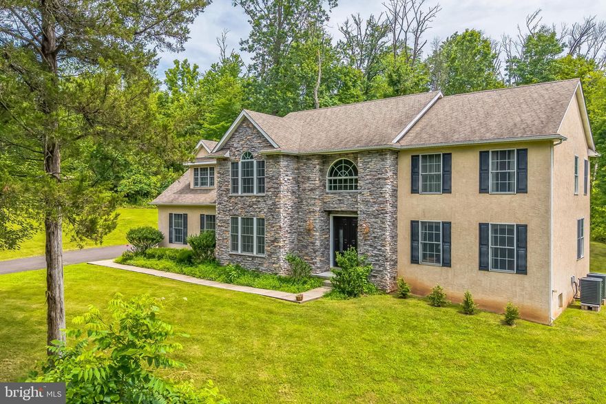 Experience timeless sophistication and modern comfort in this exceptional, custom-built residence, situated privately within the prestigious Council Rock School District and offering breathtaking long-distance views. Designed by a master builder with uncompromising attention to detail, this four-bedroom, two-and-a-half-bath estate welcomes you with a grand two-story foyer, sunlit formal living and dining rooms adorned with custom millwork, and a gourmet kitchen featuring handcrafted cabinetry, granite surfaces, premium appliances, and an inviting breakfast room. The soaring great room is the centerpiece of the home, featuring exposed beams, dramatic ceilings, and a floor-to-ceiling stone fireplace that combines warmth and elegance. The owner’s suite is a luxurious private retreat complete with a tranquil sitting area, spa-inspired bath with jetted tub, frameless glass shower, and dual vanities, while three additional spacious bedrooms and a beautifully appointed full bath enhance the upper level. A full daylight basement with high ceilings and plumbing rough-ins provides exceptional potential for customization, whether envisioned as a home theater, fitness center, or wine cellar. Additional features include a 3-car garage, new dual-zone HVAC system (2022), gleaming hardwood floors, 9-foot ceilings, recessed lighting, first-floor laundry, central vacuum, energy-efficient windows, and a security system. Outdoors, a completely private backyard oasis awaits, offering the ideal setting for peaceful relaxation or elegant entertaining. Perfectly located just minutes from fine dining, boutique shopping, cultural venues, and convenient access to major highways, trains, and airports, this rare property offers the ultimate blend of privacy, luxury, and convenience—an extraordinary opportunity for the most discerning buyer.