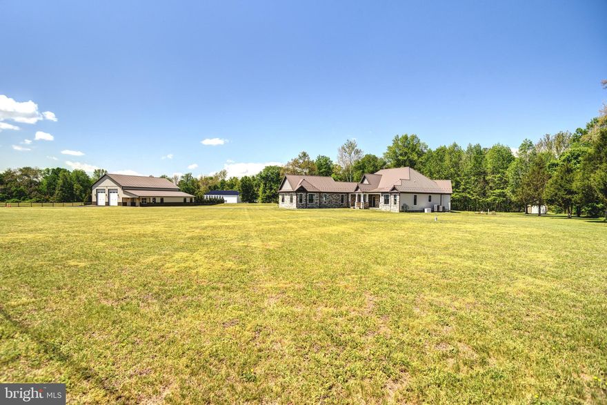 Set on just over 11 private acres in Port Tobacco, Maryland, this custom-built rambler offers the ease of single-level living paired with thoughtful design and quality craftsmanship and luxuries throughout. Built just six years ago and topped with a 50-year metal roof, the home is designed for both comfort and longevity. 

Inside, the open-concept layout seamlessly connects the foyer, living, dining, and kitchen areas, creating a bright and welcoming central space. The living room features a gas fireplace with mantle and opens to a rear porch and patio, an easy and welcomed extension for outdoor living.  

The kitchen is well-appointed with custom cabinetry, granite countertops, stainless steel appliances including a gas range and oven, dual wall ovens with air fry, convection, and microwave capabilities, dishwasher and a French door refrigerator with a built-in Keurig brewing system. 

A standout feature of the home is its three primary bedroom suites, each offering privacy and flexibility. The first overlooks the front grounds with a full bath. The second and third suites enjoy views of the rear property and direct access to the rear porch and patio. One includes a separate soaking tub and walk-in shower, while the other is more spa-like in design, with dual vanities, a freestanding soaking tub, an oversized custom shower with body jets, and an expansive walk-in closet and dressing area. 

Additional spaces include a laundry room, half bath, and mudroom just off the garage entry. The home offers 40" wide hallways, 36"+ doorways and door lever handles.  The home is equipped with Pella crank-out casement windows, remote shades, and a conditioned three-car side-load garage. Even the crawl space is climate-controlled, reflecting the attention to detail throughout. 

For added peace of mind, a 22kW Generac standby generator is in place for any power emergencies, along with an invisible pet fence surrounding the home. 

The property also features a substantial 60’ x 60’ metal outbuilding with power and two 12’ x 14’ front doors, as well as a separate 12’ x 20’ storage shed. 

Conveniently located near the Port Tobacco Marina and the many amenities of the surrounding area, this property offers a rare combination of prime location, space, privacy, and modern comfort.