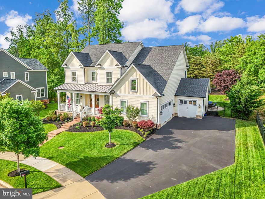 *OPEN HOUSE 6/1 IS CANCELLED** Just outside the fastest-growing suburb in the U.S.—Woodbridge, Virginia—lies Potomac Shores, named by Washingtonian Magazine as one of the top places to live in 2024. Nestled in the exclusive Fairways Overlook section of this award-winning community is a truly exceptional residence—a meticulously maintained NV Homes Empress model offering unmatched luxury, customization, and curb appeal. Set on a premium 90-foot frontage lot at the end of a quiet cul-de-sac, this exquisite home backs to mature trees and overlooks the 14th tee box of the Jack Nicklaus Signature Golf Course. With just under 4,700 square feet of beautifully FINISHED living space, every inch of this five-bedroom, four-and-a-half-bath home reflects thoughtful upgrades, refined design, and pride of ownership. From the moment you approach, the stately double French doors and pristine landscaping invite you into a home that feels right out of a design magazine. The main level showcases hand-selected finishes such as wide-plank hardwood floors and custom plantation shutters throughout.  A true dedicated office with French doors and custom built-in shelving offers the perfect work-from-home setup, while a formal living room and a dramatic navy and white dining room with tray ceiling and double crown molding create an elegant backdrop for entertaining. The gourmet kitchen is the heart of the home, featuring quartz countertops, a massive center island, double ovens, a wine fridge, and a light-filled breakfast area that opens to a stunning outdoor retreat. Step outside to your private composite deck with outdoor TV, a dual-sided gas fireplace, and a custom slate and paver patio—ideal for relaxing or hosting guests. The family room, complete with coffered ceilings and a dual-sided fireplace, creates a warm and inviting space to unwind. Upstairs, the luxurious primary suite with tray ceiling is a showstopper with gleaming hardwood floors, two spacious custom walk-in closets, and an UPDATED spa-like en-suite bathroom with dual vanities, soaking tub, and an oversized walk-in shower with dual shower heads. Three additional spacious bedrooms with NEW carpet, including one with a private bath and a shared Buddy Bath with separate vanities, provide comfort and privacy for family or guests. The upper-level laundry room is as functional as it is beautiful, featuring cabinetry and a utility sink. The fully finished lower level is designed for fun and flexibility, with a custom wet bar, beverage fridge, dishwasher, and sink—perfect for entertaining. A legal fifth bedroom, full bath, and expansive utility/storage room add practicality and room to grow. A true three-car garage ensures plenty of space for vehicles and hobbies. Additional features include a professionally landscaped backyard with an in-ground, 9 zoned irrigation system, ENERGY STAR certification, a high-efficiency two-zone HVAC system,  and Low-E windows for year-round energy savings. The HOA fee ($180/month) INCLUDES high speed internet.  Living in Potomac Shores means enjoying resort-style amenities including a state-of-the-art fitness center, three pools, 9+ miles of wooded trails, a canoe/kayak launch, the Tidewater Grill, and a vibrant social calendar. John Paul the Great private high school, Potomac Shores Middle School, Covington-Harper Elementary School and the Ali Krieger Sports Complex are right within the community, and with the Town Center and VRE station currently under construction, the convenience and value of this location are only increasing. Homes of this caliber, on premium lots, in Potomac Shores rarely come available—don’t miss your chance! Over $67,000 of recent upgrades.