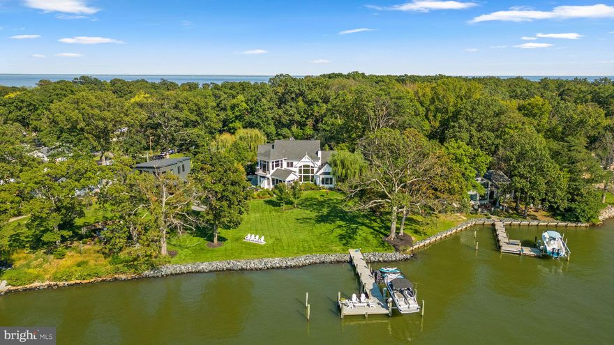 Welcome to Silver Water, a striking architectural statement inspired by the Chesapeake Bay, where refined design meets the clarity of true waterfront living. Ideally located along the serene banks of the West River, this private gated estate offers a rare sense of seclusion with convenient access to Annapolis and Washington, DC. Spanning  4,620 square feet on a meticulously landscaped 1-acre lot, the home has 5 bedrooms and 5.5 bathrooms across two levels. The clean lines, precise proportions, and high ceilings establish an immediate sense of calm. Oversized doors and expansive windows draw the water into every room, creating a constant visual dialogue with the horizon. From morning stillness to the golden glow of sunset, the water remains a captivating focal point throughout ensuring uninterrupted views of the river and bay from nearly every space. Birch engineered flooring, Pella Proline casement windows, and thoughtfully selected finishes reflect a quiet sophistication. The main-level primary suite is highlighted by a sleek fireplace and expansive windows framing breathtaking water views. The spa-inspired ensuite bath features a dual sink vanity, oversized glass-enclosed shower, and a deep soaking tub designed for relaxation. A spacious walk-in closet with custom built-ins and a conveniently integrated washer and dryer completes this exceptional private haven. The heart of the home, the gourmet kitchen is crafted for both everyday living and elevated entertaining, featuring a professional-grade 48" refrigerator/freezer and a 48" dual-fuel range. Travel out to the show-stopping pool house, designed for effortless indoor outdoor entertaining.  The interior features a kitchen and built in countertop - the ultimate hangout for hosting or relaxing. A full garage-style door extends the living space outward seamlessly to the pool patio, creating a breezy, open-air vibe. The saltwater gunite pool serves as the centerpiece of this outdoor environment— Pebble Fina finish, framed by a timeless bluestone deck and supported by a high-efficiency electric heating system for an extended season of enjoyment. Recent enhancements include a complete resurfacing in 2023 and a state-of-the-art pump installed in 2025. Complete with a pool house bath, full safety cover and comprehensive service history, it is a true turnkey luxury. Multiple bluestone patios and Teak decks lead to the manicured lawn and a fully armored shoreline with rip-rap protection. A 24-zone smart irrigation system maintains the grounds with precision, with mature landscaping ensuring privacy and tranquility. For the waterfront enthusiast, the property offers direct access to the Chesapeake lifestyle. A 70-foot pier, approximately nine years old, is equipped with power and a 10,000 lb Magnum boat lift. Additional features include dual-fuel 3-zone HVAC systems, two tankless hot water heaters, a 3-car detached garage and dedicated storage barn. This is waterfront living at its most intentional and refined, where stillness, design, and nature converge to create an extraordinary and enduring retreat—and where each sunset becomes a daily, celebrated event. Don’t miss your opportunity to make this exceptional property your own. Schedule your private tour today!