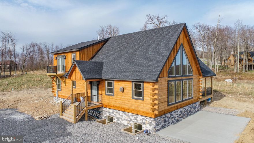 Luxury New Construction Log Home at Deep Creek Lake – Ski Slope Access, Expansive Mountain and Sunset Views, and Rustic Charm. Welcome to your dream mountain escape! This brand-new 7-bedroom, 6.5-bathroom log home is perfectly perched above Deep Creek Lake in the coveted ski-in/ski-out North Camp community atop the Wisp Resort area, offering direct ski slope access, a cul-de-sac location, and panoramic mountain views that stretch for miles. Spanning three fully finished levels, this rustic retreat blends luxury with authentic cabin charm. Inside, you'll find soaring wood ceilings, warm wood finishes, and custom rustic décor throughout. The heart of the home is the kitchen, outfitted with stainless steel appliances, two refrigerators, and a stunning live edge wood island, perfect for entertaining after a day on the slopes. Just off the dining area, a live edge coffee bar adds a cozy, lodge-style touch. The living room has an impressive stone fireplace. Step outside onto the covered deck to take in the fresh mountain air, or gather on the oversized concrete patio with family and friends to soak in the distant mountain views. The primary suite is a private sanctuary, featuring its own balcony with jaw-dropping sunset views over the mountains—truly a scene to remember. Also featuring 5 bedrooms with their own private bathrooms, a large lower level family rec room, a loft, oversized ceiling fans, modern rustic light fixtures, an oversized parking area, and tankless hot water. Whether you're hosting a crowd or enjoying a quiet mountain getaway, this home offers plenty of space, comfort, and style in one of Maryland’s most desirable year-round destinations. Rental projection up to $103K!! Don't miss your chance to own a piece of Deep Creek Lake paradise—schedule your private tour today!