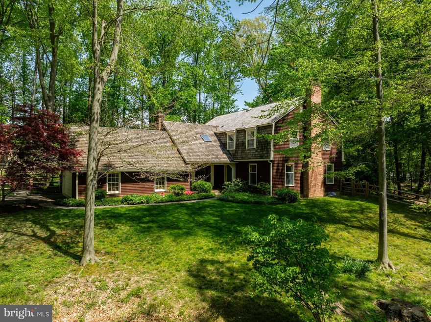 Nestled within the serenity of a private 1.75-acre wooded lot, this 5-bedroom, 3.5 bath home is located in the award winning Wissahickon School District. With a thoughtfully crafted layout and vistas of the surrounding landscape, this home provides an idyllic sanctuary just steps away from the 82-acre Prophecy Creek Park, the 33-acre Briar Hill Preserve, Cheston Family Preserve, and Armentrout & Camp Woods which are accessible through a gate on the property.

A charming covered brick front porch leads to the gracious foyer with slate floor and double closet. The expansive living room boasts a striking brick fireplace and hardwood flooring. The sunlit kitchen is a chef's delight, featuring an abundance of cabinetry, newly installed gas cooking, two ovens (one convection), a built-in microwave, and tiled flooring. 

The adjacent dining room, enhanced by glass French doors, serves as an intimate gathering spot. The expansive great room is highlighted by a second enormous brick fireplace complemented by custom built-in cabinetry. Hardwood floors, a beamed ceiling, and picturesque sylvan views in every direction complete the ambiance. Sliding glass doors provide access to a covered patio, perfect for al fresco dining or relaxation. Convenience meets functionality with the first of two well-placed laundry rooms located off the kitchen, designed to serve as a practical mudroom with ample cabinets, a utility sink, and direct patio access. Rounding off the main floor is a powder room with slate floors.

The well-appointed primary bedroom suite is a haven of comfort and style, offering breathtaking views via a huge bay window with sills made for a comfy reading nook, two generous walk-in closets, and an ensuite bathroom complete with a double sink vanity and a separate water closet with tiled stall shower. A second bedroom with its own ensuite bath provides versatility. This bedroom has access to a spacious, unfinished attic space that holds potential for a convenient kitchenette to accommodate multigenerational living (in-law or au pair suite) or guests (plans available). Completing the upper level are three additional generously sized bedrooms, a hall bath with spa tub, and the second laundry room for added convenience. The large finished basement provides ample space for recreation or fitness pursuits.

Outside, multiple expansive patios, a babbling stream, and landscaped gardens beckon you to relax and unwind in this secluded oasis. Situated just minutes from downtown historic Ambler, with its charming cafes and theaters, as well as major transportation routes, schools, parks, and amenities, this home offers the perfect blend of privacy and accessibility.  Tour this exceptional retreat today!