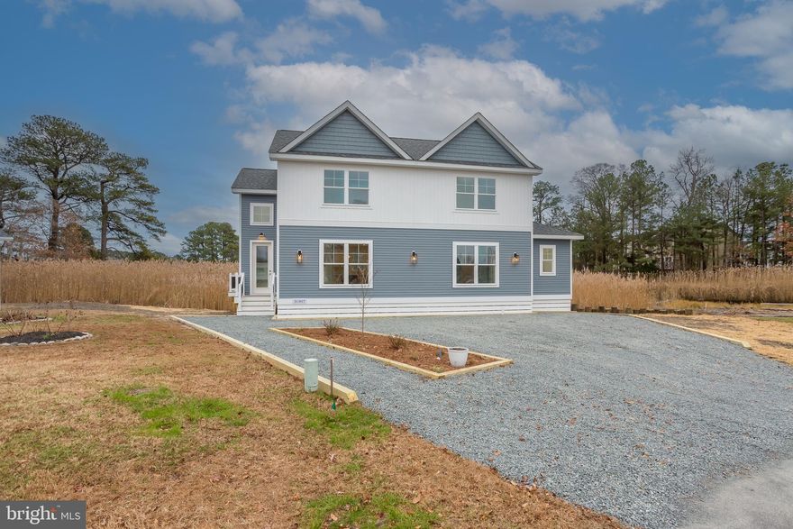 Recently repositioned and fully complete, this custom-built home offers a rare opportunity to own newer construction just minutes from Bethany Beach—set on a private .65-acre cul-de-sac homesite backing to protected wetlands.

Designed for how today’s coastal buyers want to live, the home combines true first-floor functionality with flexible second-level space. The main level is anchored by a first-floor owner’s suite and approximately 1,245 square feet of primary living space—comparable to many single-level homes— supporting everyday ease, while the upper level adds approximately 855 square feet of additional bedrooms and loft space, ideal for guests, workspace, or extended living without compromising day-to-day comfort.

Positioned as a 3-bedroom home with a flexible 4th room, the layout allows buyers to tailor the space to their needs, whether as an office, den, or additional bedroom.

The open-concept interior is filled with natural light, featuring 9-foot ceilings, oversized windows, and a modern cable-rail staircase that adds architectural interest. The kitchen is thoughtfully designed with white shaker cabinetry, quartz countertops, stainless steel appliances, pendant lighting, and a spacious center island suited for both everyday living and entertaining.

The homesite is a standout feature—backing to protected wetlands, it offers a level of privacy and depth that cannot be replicated within the community. The design prioritizes interior living space and the rear setting, with a wide stone driveway and curated exterior elements that emphasize low maintenance and a clean, coastal aesthetic.

Built by Amish craftsmen, the home reflects quality construction and thoughtful execution throughout. Additional features include split HVAC systems for efficient year-round comfort, public water and sewer, and low HOA fees—all within close proximity to Bethany Beach, golf, and coastal amenities.

Flood insurance policy is currently active and transferable at settlement, with elevation certificate on file.

Certificate of Occupancy has been issued—the home is fully complete and available for immediate settlement.

Homesite includes protected wetlands and regulated building constraints, limiting the ability to replicate similar new construction within this setting. Select interior photos have been virtually staged for illustrative purposes.