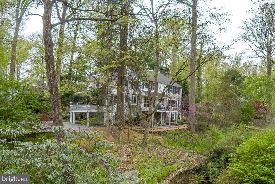 Nestled at the end of a private cul-de-sac, this timeless residence masterfully blends enduring craftsmanship with thoughtful modern updates, offering a lifestyle of effortless elegance in the heart of prestigious Lower Merion Township. Ideally located within walking distance to vibrant Suburban Square and both Amtrak and SEPTA train stations, this home provides the perfect balance of privacy, convenience, and charm.

Warm and welcoming, the home is filled with natural light, richly hued hardwood floors, and sweeping views from nearly every room. From the moment you arrive, it feels like a welcoming vacation destination — a true retreat just minutes from everything.

At the heart of the home, a gracious sitting room adjoins the beautifully renovated kitchen, where sunlight pours through oversized windows, framing the gardens like living artwork. The kitchen and baths have been meticulously updated, seamlessly marrying classic character with contemporary convenience. The formal dining room, enhanced by elegant French doors, opens to a private balcony—an idyllic setting for morning coffee or evening aperitifs with a view.

The inviting library offers a quiet retreat, featuring direct access through a charming door to a secluded flagstone patio surrounded by lush greenery. Outdoors, two additional flagstone patios encourage effortless indoor-outdoor living, while a sparkling swimming pool and meandering garden paths invite relaxation, reflection, and connection to nature.

The finished lower level expands the living space and features spacious game room with a fireplace.  This room exits to  an wonderful patio with incredible views of the property's bucalic setting, waterfall, and fire pit area. This level also features a dedicated wine storage room and a convenient laundry area.  A heated garage completes the home, adding year-round practicality and comfort.

The setting of this conveniently located property is incredible.  Woodland views highlighted with specimen trees and shrubbery surround you.  There is no traffic noise here, just the sounds of birds, owls and the gentle sound of the two waterfalls on the property.  Incredibly private, peaceful, and undeniably enchanting, this is a home that invites you to slow down, savor every moment, and live beautifully.

A Pre-Listing Inspection is available; this house is in excellent condition, ready for you to enjoy!  Floor plans are also available.