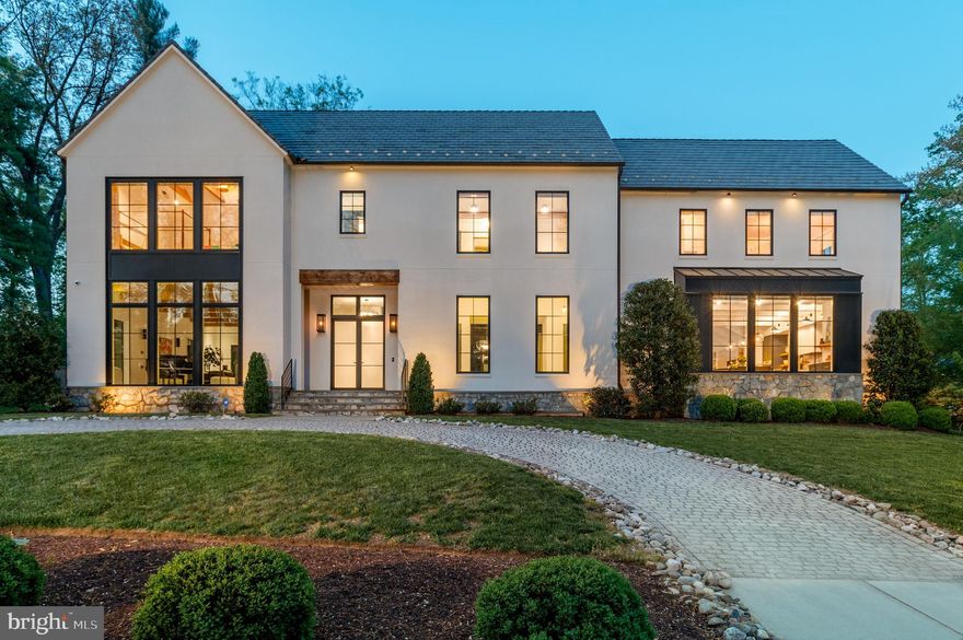 Set on a prominent .75-acre corner lot, 7101 Longwood Drive is a masterfully executed custom residence with design-forward panache. Built in 2018 by GBI Builders, designed in collaboration with architect Carmel Greer and interior designer Julie Geyer, this stunning home spans 9,100 square feet across four meticulously finished levels. The home unfolds with a sense of scale (note the 11’ ceilings on main level), light, and intention at every turn with high-end designer finishes including stunning custom lighting. Outdoors, the home transforms into a private resort surrounded by mature trees and landscaping for added privacy with a stunning heated in-ground pool, expansive patio, and outdoor kitchen. A grand, light-filled foyer makes an unforgettable first impression with a Murano glass chandelier and anchored by a sweeping, sculptural staircase with refined detailing that rises dramatically through the home. Wide-plank white oak hardwood floors, elegant millwork, and soaring ceilings carry throughout, setting a cohesive tone of understated luxury. Formal living and dining rooms are both gracious and inviting—ideal for entertaining—while the dining room connects seamlessly to the kitchen via a fully outfitted butler’s pantry, complete with custom cabinetry and additional prep space. The formal living room is anchored with a fireplace, white oak wood in ceiling beams, and doors leading to the covered patio with retractable screens. The kitchen is a true centerpiece: an expansive, chef-caliber space with Calacatta Vagli counters and backsplash, an oversized island, high-end appliances (including a Dacor range and fridge/freezer), custom cabinetry, Brizo fixtures, and designer lighting. A sun-drenched breakfast nook, wrapped in windows and additional built-in cabinetry. The kitchen flows effortlessly into the family room, where a statement fireplace and coffered ceilings create a warm yet elevated gathering space. Large glass doors blur the line between indoors and out. A private office with bespoke built-ins offers a quiet retreat, while a thoughtfully designed mudroom with ample storage connects directly to the three-car garage. Finishing this level are two powder bathrooms. Upstairs, the primary suite is both serene and sophisticated, featuring white oak wood in ceiling beams, custom automated window treatments, dual custom walk-in closets, and a spa-like bath clad in luxurious finishes —complete with Nero Marquina marble counter and floors, a freestanding soaking tub, oversized glass-enclosed carrara shower and walls, waterworks hardware, and dual vanities. Three additional bedrooms are beautifully appointed, accompanied by two well-designed baths and a versatile lounge space ideal for relaxing or studying. The top level provides an additional private suite. The lower level is designed for indulgent living and entertaining, featuring a sprawling recreation space, a showstopping wine cellar—with a biometric lock, standalone cooling system, extensive storage and space for a tasting table—serves as both a functional and visual focal point. This level also includes a fitness room, an additional bedroom and full bath, and storage. The professionally landscaped exterior serves as an extension of the home and is the perfect place to enjoy the upcoming summer months. A beautifully designed patio anchors the backyard, featuring a covered living area with retractable screens, heaters, a fan, and a fireplace. The outdoor kitchen is fully equipped  with Granite countertops, a mini-fridge, built-in grill and gas burner, warming drawer, and ice maker for effortless entertaining, while the pool—set against lush landscaping—creates a striking and tranquil backdrop. A circular driveway enhances the home’s stately curb appeal, complemented by a secondary driveway leading to the side-entry three-car garage.