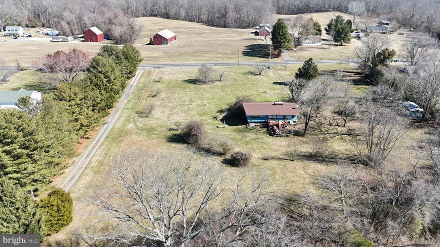 Fantastic opportunity to own and renovate an architecturally striking Acorn Deck Home, situated on 3 pastoral FLAT acres in Port Republic.  Original features throughout waiting to be revived and made into a unique dream home.  Features include walls of windows framing the views, exposed architectural beams, vaulted ceilings, open floor plan, two brick fireplaces, original Deck Home features like the iconic Waffle door and character only found in these interesting homes.  The lot is large and flat, and features stunning views or surrounding farmland and historic Tobacco Barns.  NO HOA to limit usage or potential desired improvements like pole barns, a pool, detached garage, etc.  Bring your vision to this one of a kind property and you will be rewarded with years of enjoyment and an impressive home to entertain friends and family.