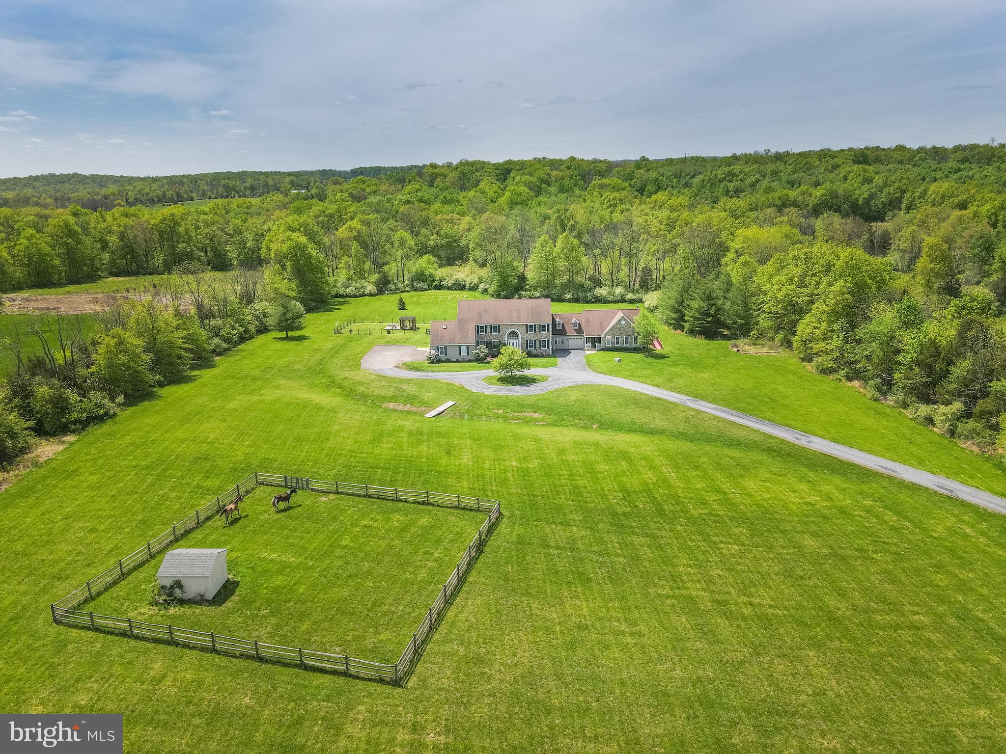 Are you looking for a special retreat in Bucks County with an attached in-law suite and endless possibilities? Welcome to Keystone Country Home with 7 bedrooms, 5-1/2 bathrooms on 13+ fabulous acres. As you meander down the driveway, you’ll get a sense of the private setting this home offers. Don’t forget to notice the fenced pasture ready for horses! Come with your imagination as you enter into the 2 story foyer with a sweeping curved staircase. The great room with 30 ft ceiling,  a handsome stone wall and a cozy woodburning stove will take your breath away, along with the views of your bucolic property. The modern kitchen offers a large island, double oven, 5 burner cooktop, an abundance of cabinetry and counterspace, space for a wine refrigerator, breakfast room and a butler’s area into the great room. The inspirational spiral staircase in the kitchen, leads you to the 2nd and 3rd floors. Enjoy the spacious dining room for entertaining and those special holidays. The tile flooring on main floor is with radiant heat. There is a first floor primary suite with walk-in closet, full bathroom and bonus room that would make a great fitness room, Zoom room or office. There is also a 2nd primary suite on the 2nd floor, along with a spacious 2nd floor landing overlooking the great room, two additional bedrooms with a Jack and Jill bathroom, and a bonus room to complete the 2nd floor. The third floor offers 2 more bedrooms, a full bathroom and a sitting area. We cannot forget the in-law suite (most recently used as a recording studio) which adds another bedroom, full bathroom, 2 story living room, full kitchen, private deck with ramp, and it’s own one car garage! The backyard has room to roam and comes with a grilling area and firepit. Let your imagination run free while making this property your own. The grounds have been kept fully organic and could be farmed. The front field is currently being farmed by a local farmer. Simple subdivision possibility. Home currently is Act 319 offering, allowing for reduced taxes. Easy access to major corridors including Rts 309 & 313, I-78, Northeast Extension. Minutes to shopping and restaurants. Home is being sold "as-is".