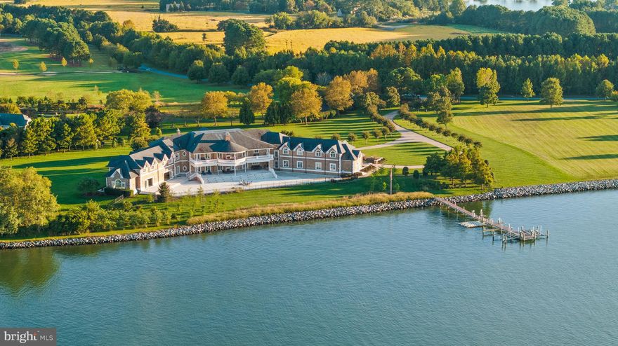 Discover an extraordinary 6.8-acre waterfront estate on Morgans Point, meticulously crafted for those who seek modern luxury infused with timeless elegance. This custom-designed residence seamlessly blends sophistication, comfort, and exceptional craftsmanship.

A private, tree-lined drive leads to an expansive motor court, setting the stage for the grand two-story foyer that welcomes you inside. Spanning over 24,000 square feet across three levels, this home is designed for both lavish entertaining and relaxed everyday living. The gourmet chef's kitchen (the heartbeat of this home) is equipped with top-tier appliances and custom cabinetry. It flows effortlessly into a spacious covered terrace, offering stunning water views and an ideal space for outdoor living.
The main level features a gracious family room, formal dining room, serene sitting room, paneled library, fitness room, sauna, and a glass-enclosed heated indoor pool with a hot tub. A convenient main-level guest suite with patio access adds to the home's versatility, while an elevator connects all floors for ease of movement.

The bedroom layout is thoughtfully designed as a private retreat, featuring two luxurious primary suites, three additional ensuite bedrooms, and a separate in-law/au pair suite. The main primary suite is a sanctuary, complete with dual bathrooms (one with heated floors and an "in-mirror TV"), a cozy sitting area, a fireplace, and a large covered balcony overlooking the serene river.

Outdoor spaces are designed to maximize the breathtaking water views, with expansive covered areas and a resort-style terrace. The private pier, equipped with two boat lifts, four jet ski lifts, and a floating dock (5' MLW, buyer to verify), offers endless opportunities for waterfront enjoyment.

The lower level is an entertainer's dream, featuring a full bar, wine cellar, game room, secondary kitchen, theater room, and a discreetly located safe room with a vault and full bath for added security.

Car enthusiasts will appreciate the expansive 73x30 four-car garage with soaring ceilings, complemented by an additional in-law/au pair suite above, complete with a full kitchen and family room.

Nestled in the tranquil town of Oxford, this estate offers privacy and serenity while remaining conveniently close to shopping, dining, entertainment, medical facilities, and the Chesapeake Bay. Major commuter routes provide easy access to Washington, DC, Northern Virginia, Annapolis, and Philadelphia, with four major airports: BWI (71 miles), DC (74 miles), Dulles (112 miles), and Philadelphia (113 miles).

Embrace the Eastern Shore lifestyle and live the Bay Life in unparalleled luxury!