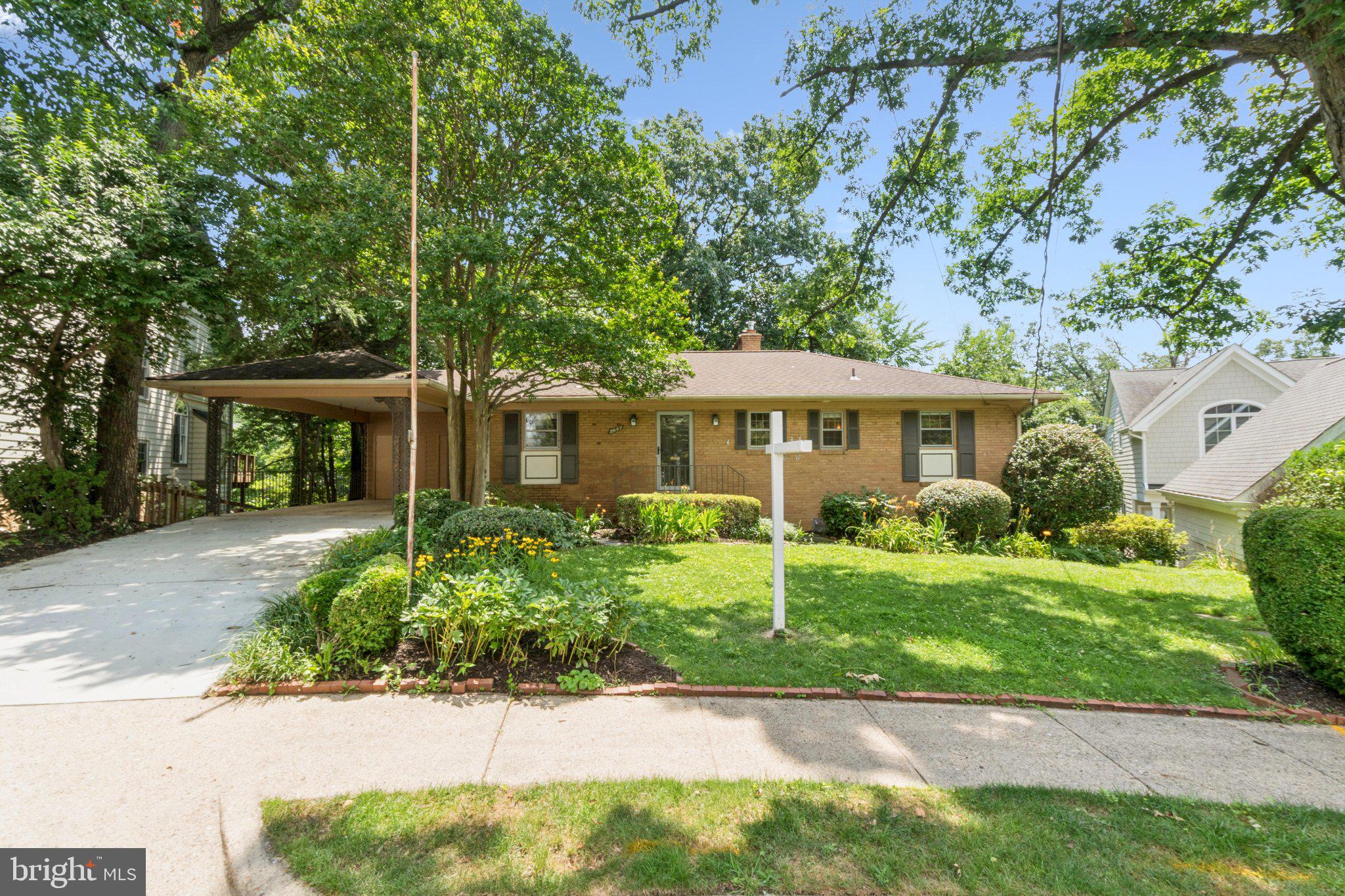 This impressive midcentury rambler is tucked away on a quiet street and situated on a wide 7851sf lot in Oakcrest. A brand-new driveway leads to a covered carport plus additional storage shed, allowing for at least two cars off street. Mature landscaping accents the home and a walkway leads to the front door of this 2,700sf two level home. Foyer entry with slate tile floor has sightlines into the large living room, and beautiful hardwood floors are carried throughout the entire main level. The open concept floor plan accented with traditional elements make this home great for everyday living as well as entertaining and large gatherings. Large kitchen has a side entrance from carport, boasts abundant white cabinetry, granite countertops, a large food pantry and could easily be opened into the living room and dining room. Living room features a gas fireplace and looks out through a picture frame window over the back deck and backyard. A large main level owner’s suite is suitable for a king-sized bed, has multiple closets and overlooks the backyard. En-suite bathroom has been tastefully renovated, features elegant hexagon floor tile and a frameless glass enclosed shower. Second and third main level bedrooms are spacious, with large windows, excellent closet space and each have a ceiling fan. Renovated hall bathroom has an oversized vanity with abundant storage, basketweave floor tile and bathtub with subway tile surround. Walk-out lower level is anchored by a large great room featuring the second fireplace and abundant built-in shelving. Lower-level den with tons of built-in shelving and sliding glass doors to covered area under the deck. Lower level also includes the fourth bedroom, third fully renovated bathroom, laundry room, utility room, storage space and a large workshop. Secluded backyard oasis is fully fenced and provides abundant privacy from mature trees and backs to Oakcrest Park. Supreme location within the most convenient neighborhood throughout the entire D.M.V. – Zero stoplights to Washington D.C., close to Metro, schools, shopping, dining and grocery stores including Whole Foods. Easy access to the Pentagon, Amazon’s new National Landing HQ2 Headquarters, Virginia Tech Innovation Campus, proximity to I-395 and much more!