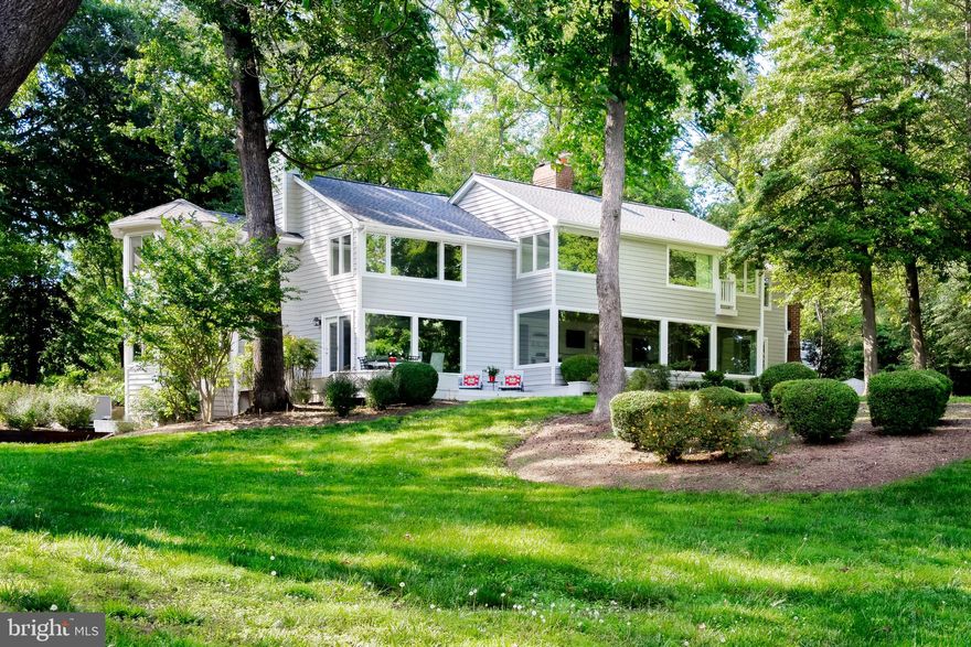 Move right in and enjoy private and serene waterfront living on nearly 4 acres along Meredith Creek. This unique property provides protected, deep water access with 8-foot MLW at the end of the pier, and has  accommodated a 65-foot yacht. The waterfront includes a rare covered boathouse and two boat lifts, enhancing your boating and water sports experience. The property, surrounded by mature trees, is reached by a long private drive and features 534 feet of gently sloping shoreline and  easy access to the pier and waterfront.  The spacious 6,300+ square foot home includes 5 bedrooms and 5.5 baths, making it ideal for both family living and entertaining. Recent renovations completed in 2023-2024  include a high-end chef’s kitchen with marble counters, a luxurious primary suite with marble flooring, refinished hardwood floors, and completely updated bathrooms. Most windows have been replaced, and a new roof has been installed. The home’s layout, with generously sized rooms, emphasizes comfort and entertaining, with a spacious outdoor deck offering panoramic  creek views.  The finished basement features  two large recreation rooms, a full bath and utility spaces.  A large mudroom with a utility sink and abundant storage sits conveniently next to the covered portico. The property also includes garage parking for 4 cars and a circular driveway that accommodates additional guest parking. A pool permit is approved, allowing future expansion. Nestled off a quiet country road with no road noise, this property provides easy access to Route 50, combining the tranquility of waterfront living with the convenience of nearby commuting routes. This home blends luxury, privacy, and ease of access, making it an exceptional retreat on the water.