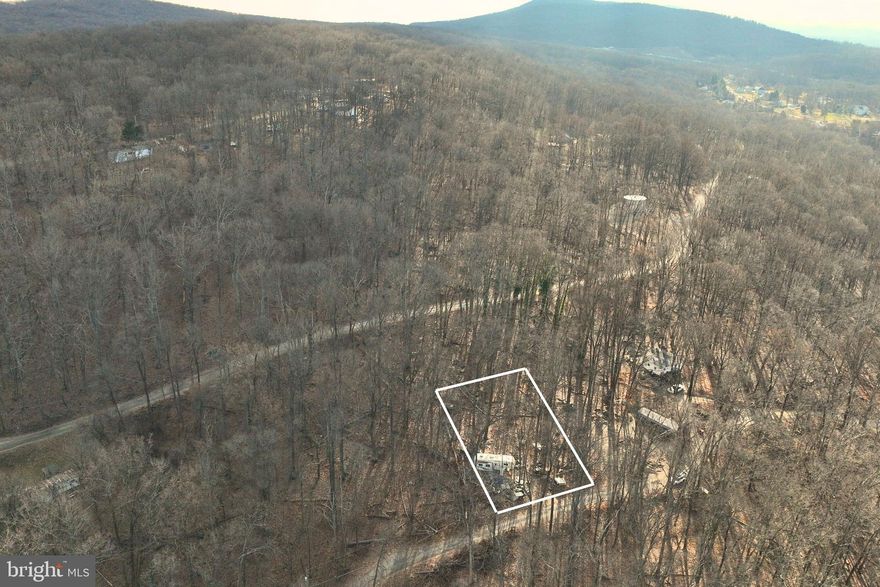 Private wooded lot located on Woodpecker Lane in Harpers Ferry.  With 81 feet of road frontage and an existing driveway, this 0.24 acres parcel offers direct access and flexible use options thanks to no zoning restrictions.  Gently wooded with a moderate slope, the property provides privacy while maintaining proximity to nearby homes, increasing the likelihood of utility connections.  No wetlands, no flood zone and no HOA restrictions.  Conveniently located near commuter routes, shopping and outdoor destinations.  This parcel is ideal for future homesite, recreational use or long-term investment in a quiet mountain setting.