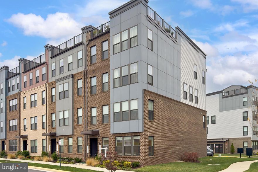 Modern end unit 2-level townhome-style townhome with garage in the sought-after Ashbrook Place community, built in 2022! This beautifully designed home offers an open-concept main level with high ceilings, warm light oak luxury vinyl plank flooring, and tons of natural light from an abundance of windows on 3 sides. Spacious living and dining areas flow into a gourmet kitchen with pristine white 42” cabinetry, beautiful quartz countertops, stainless steel appliances, wall oven, built-in microwave, cooktop with sleek suspended hood vent, and a large peninsula island — perfect for entertaining. A convenient half bath and garage access completes the main level. Upstairs features two generous bedrooms, a versatile loft area with balcony access (easily converted into a third bedroom), and a hall bath with tub/shower combo. The primary suite boasts a wall of windows, plush carpeting, two walk-in closets, and a private spa-like ensuite bath with a dual sink vanity, water closet, and an oversized frameless glass enclosed shower. The attached 1-car garage plus driveway parking adds convenience. The community offers great amenities including bike trails, a dog park, and beautifully maintained common areas. Prime location — just a 5-minute walk to One Loudoun for shopping, dining, and entertainment, and easy access to Dulles Airport, Metro, and DC. If you’re looking for a stylish, contemporary home, featuring designer finishes, comfort, and convenience, look no further this is it!